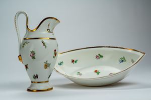 Ewer with oval basin in porcelain, decorated in polychrome with scattered flowers and sprigs, gilt rims. France, early 19th century