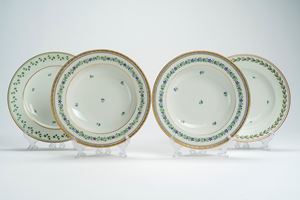 Lotto composto da una coppia di piatti fondi in porcellana decorati in policromia a fiordalisi sparsi e profilati in oro e da altri due piatti fondi con decoro a ghirlande di foglie e fiorellini sparsi con profili dorati. Vienna, fine secolo XVIII-inizio secolo XIX