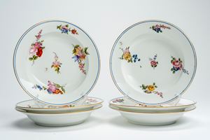 Six porcelain soup plates, decorated in polychrome with scattered flower bouquets, gilt rim and cobalt-blue line. Sèvres, 18th century