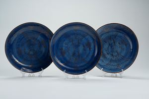 Tre piatti in porcellana con invetriatura powder blue e decori dorati. Cina, secolo XVIII/XIX