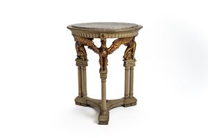 Guéridon in legno laccato a fondo bianco con base triangolare. Supporti a guisa di colonne a tutto tondo, sormontate da grifoni alati e dorati che reggono il piano con marmo incassato. Inizi XX secolo.Appartenuto al compositore Pietro Mascagni (1863–1945).