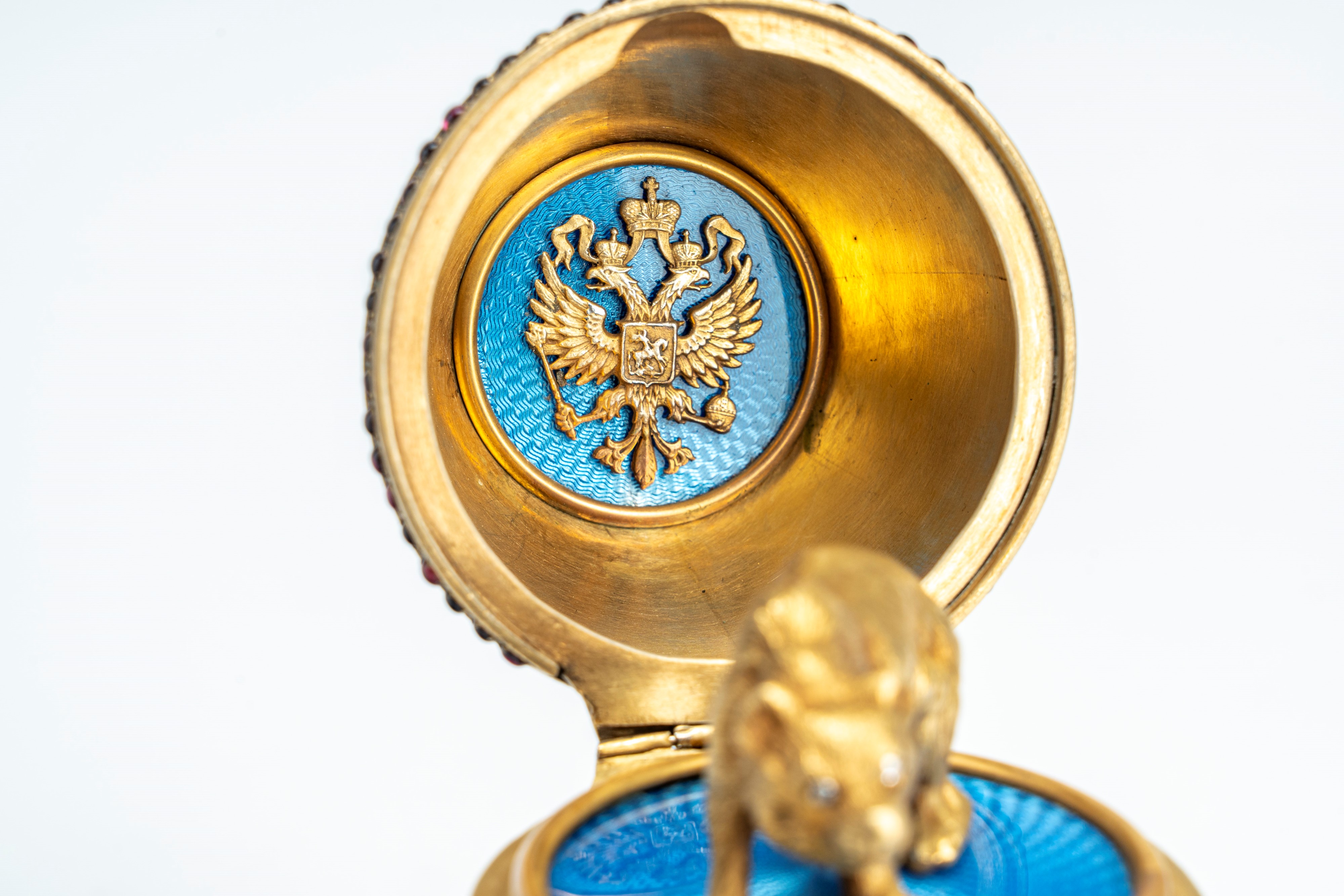 Uovo sormontato da corona in argento dorato, cesellato con smalti policromi cloisonné e guilloché...