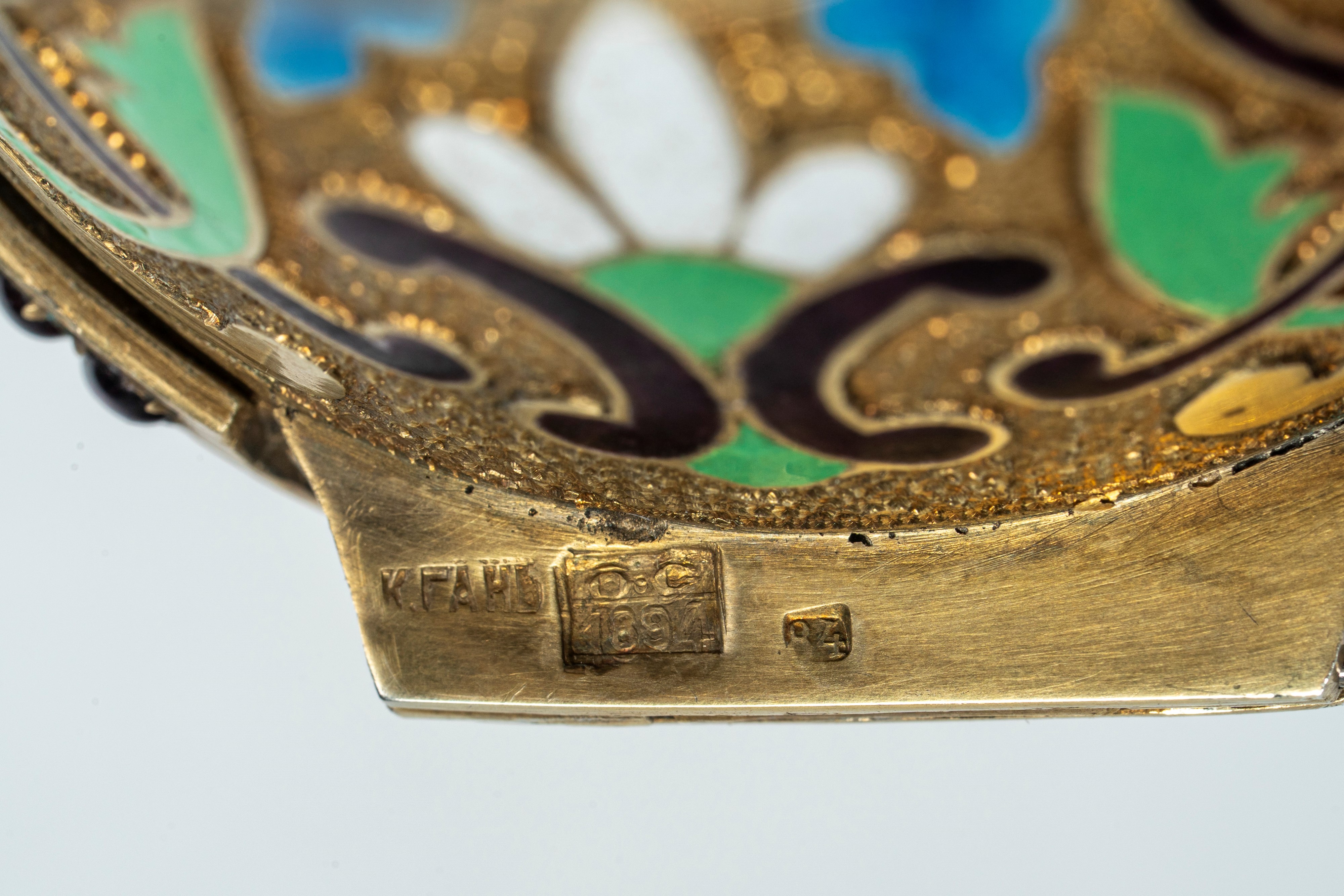 Uovo sormontato da corona in argento dorato, cesellato con smalti policromi cloisonné e guilloché...