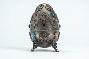 Silver egg, chased with imperial double-headed eagle friezes, polychrome enamels and cabochons, resting on four openwork feet. Russia, 19th century