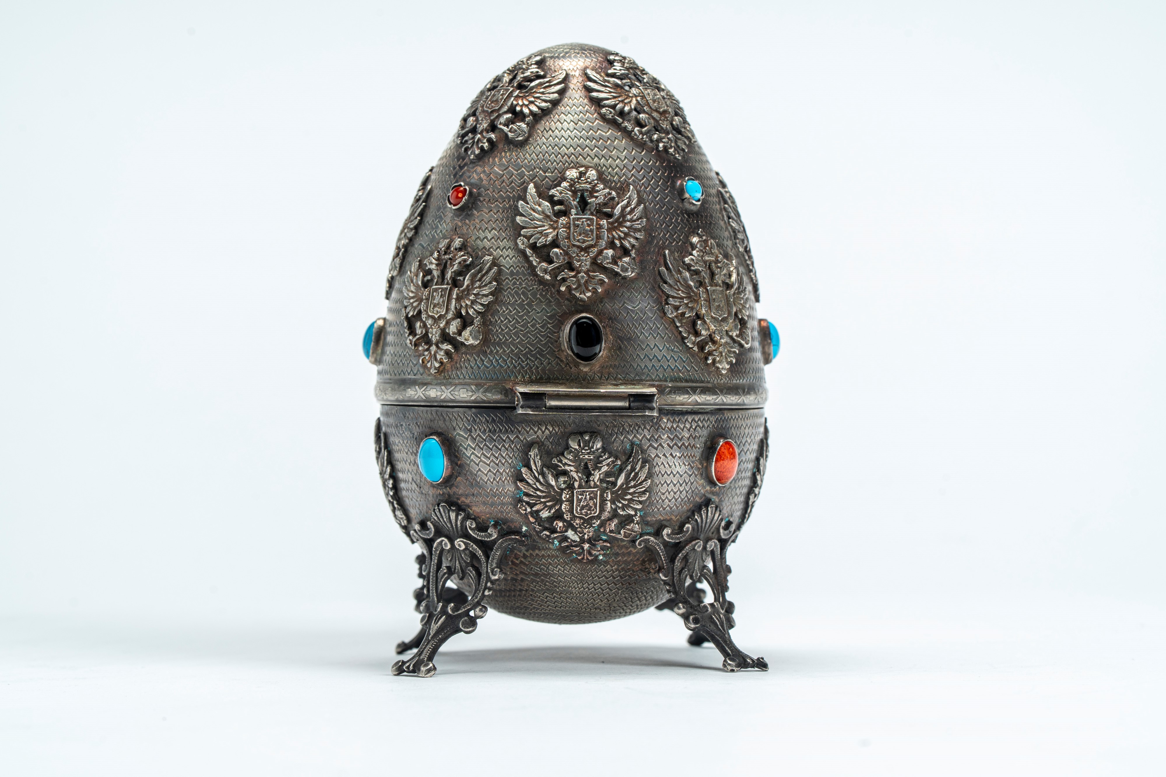 Uovo in argento cesellato con fregi ad aquila bicefala imperiale, smalti policromi e cabochon, po...