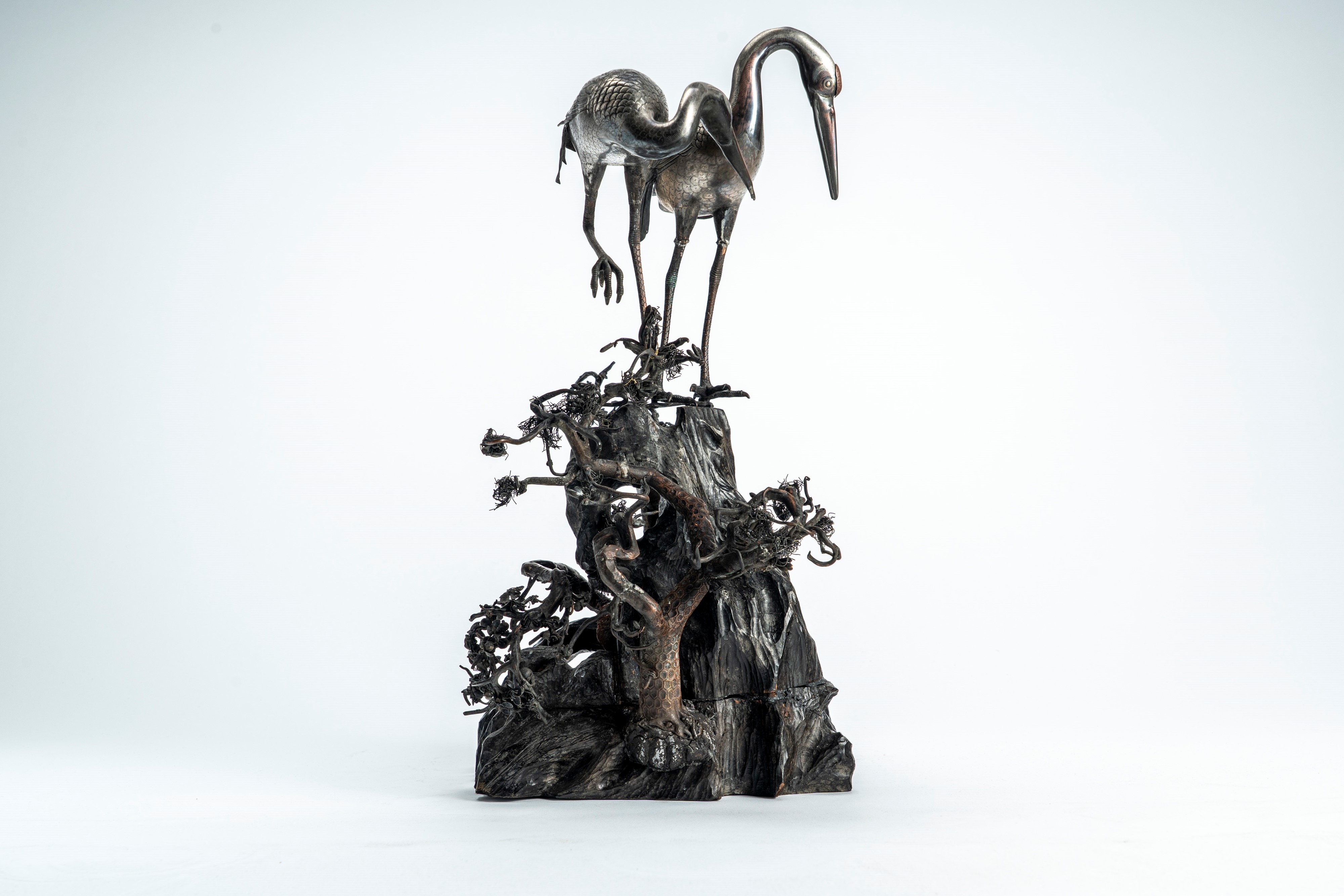 Grande okimono in legno e metallo parzialmente argentato, raffigurante una coppia di gru su tronc...