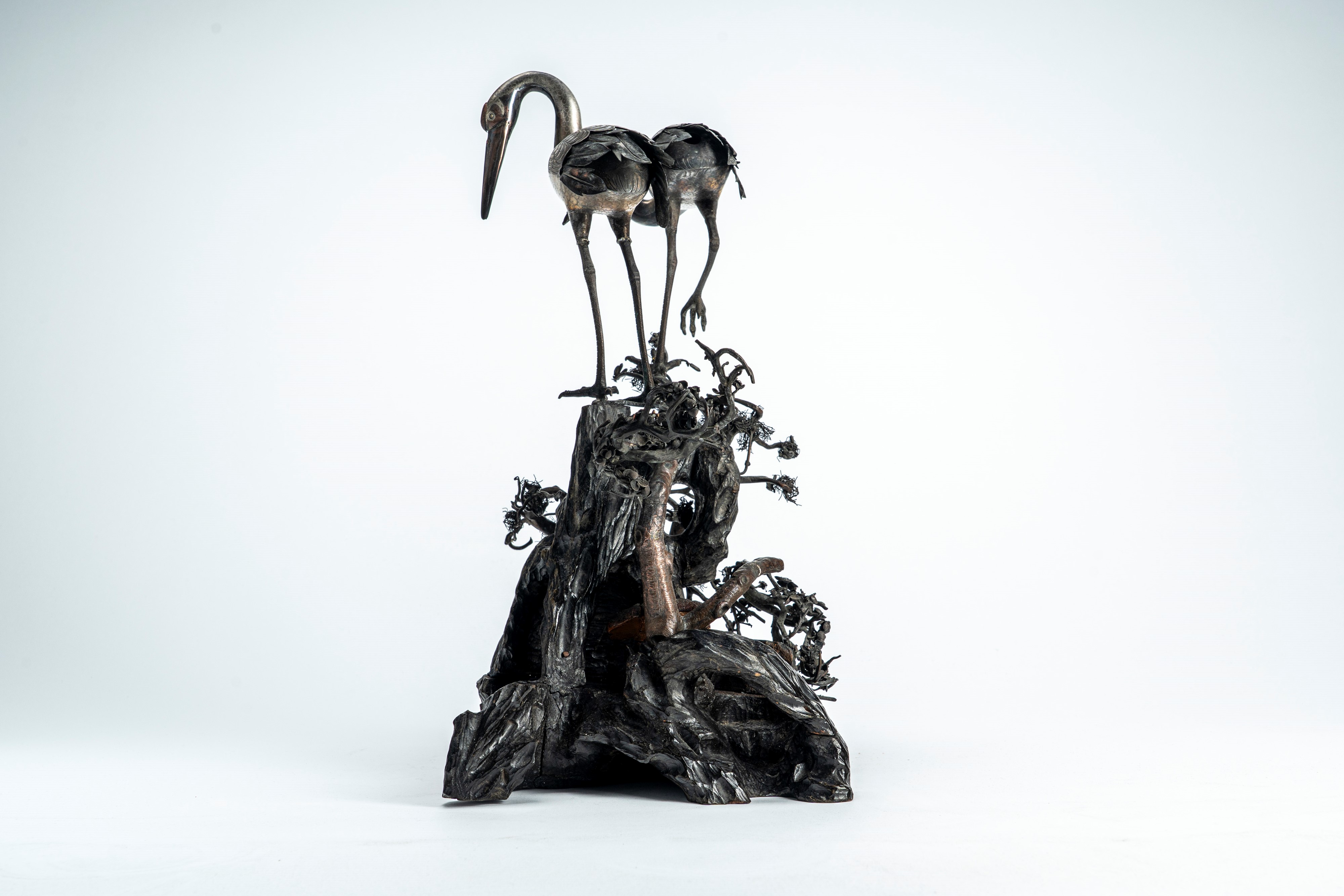 Grande okimono in legno e metallo parzialmente argentato, raffigurante una coppia di gru su tronc...