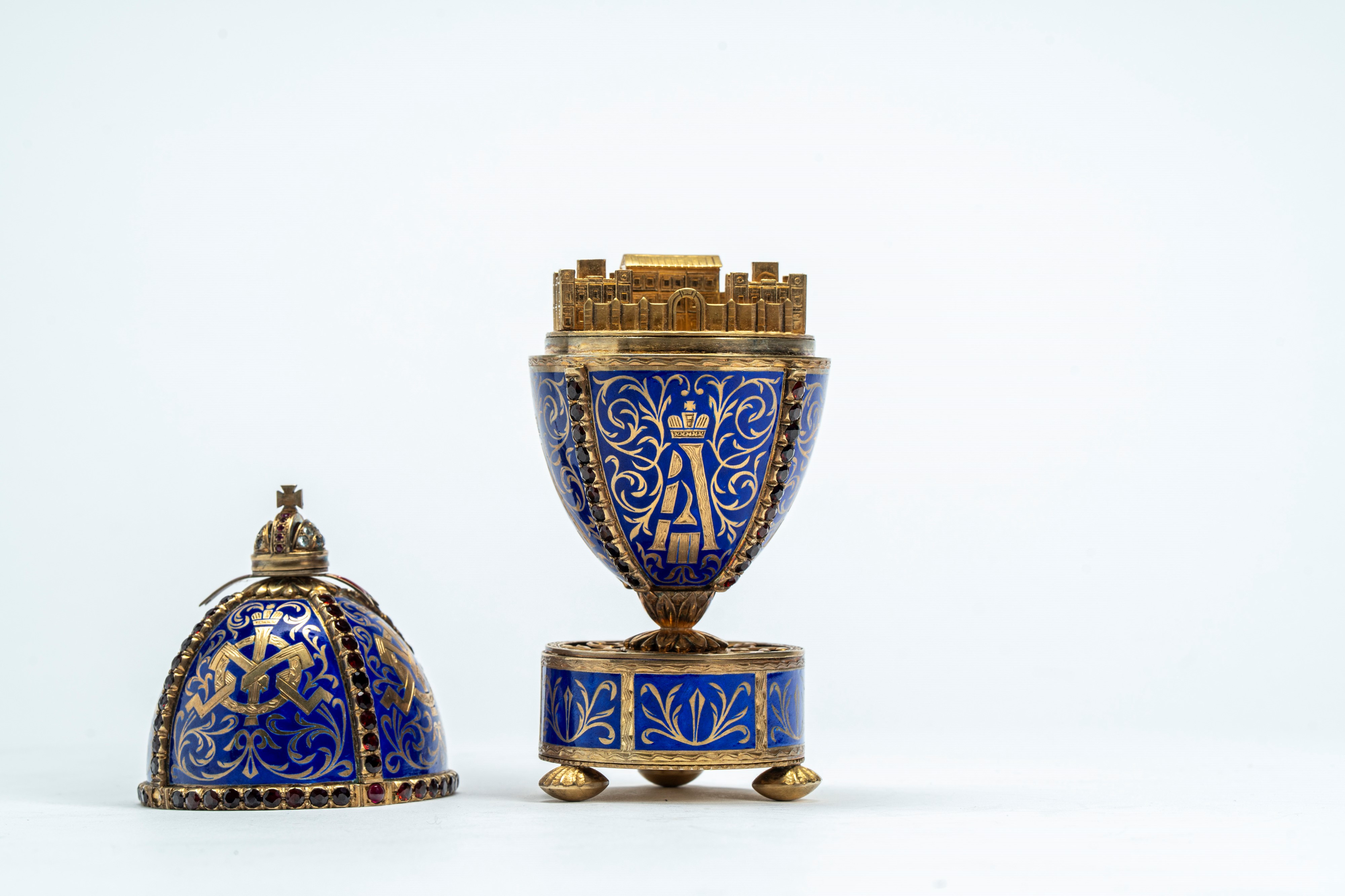 Uovo in argento dorato e smaltato a fondo blu, poggiante su base circolare con tre piedini. San P...