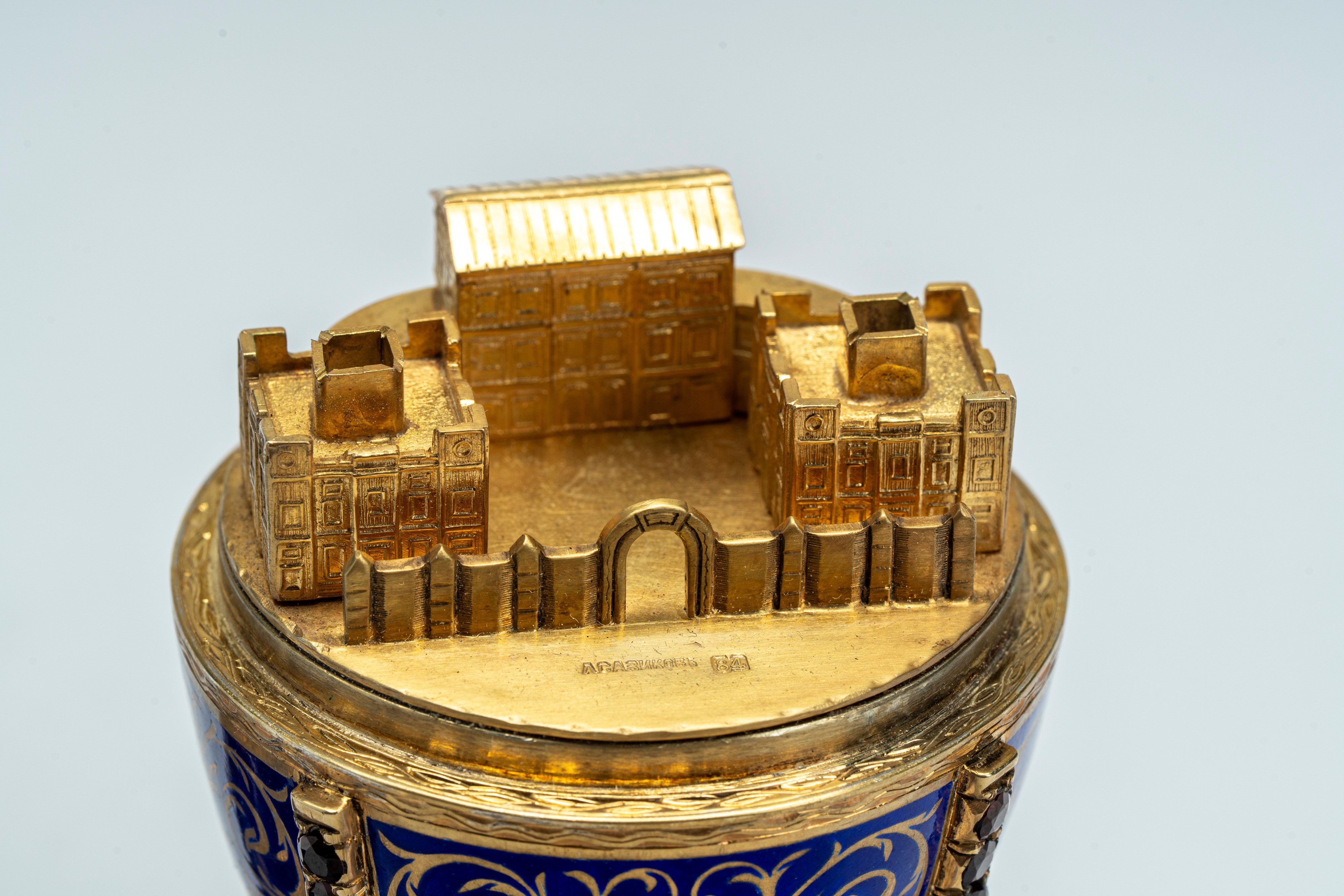 Uovo in argento dorato e smaltato a fondo blu, poggiante su base circolare con tre piedini. San P...