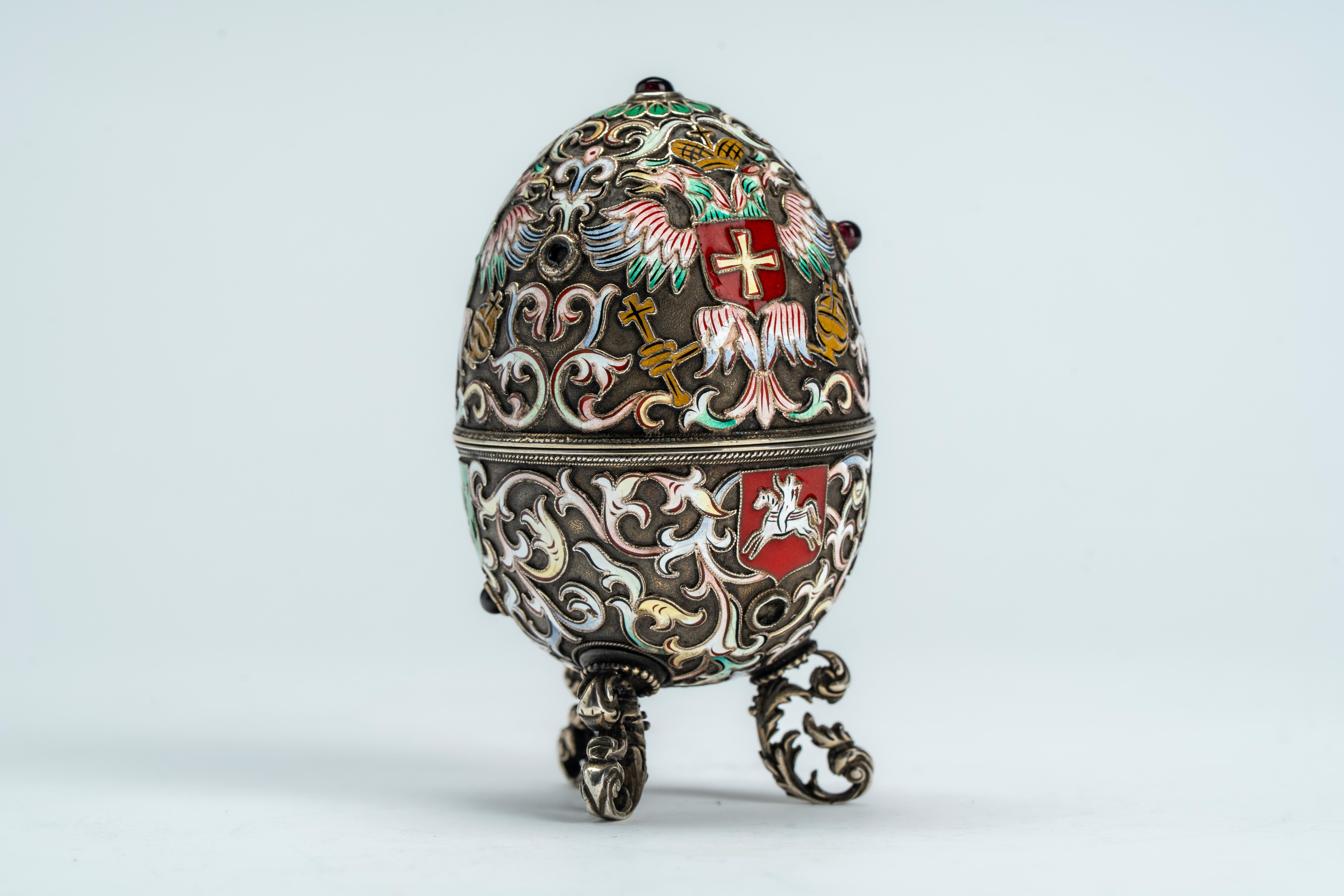 Uovo in argento con smalti policromi cloisonné e cabochons, poggiante su tre piedini a volute fog...