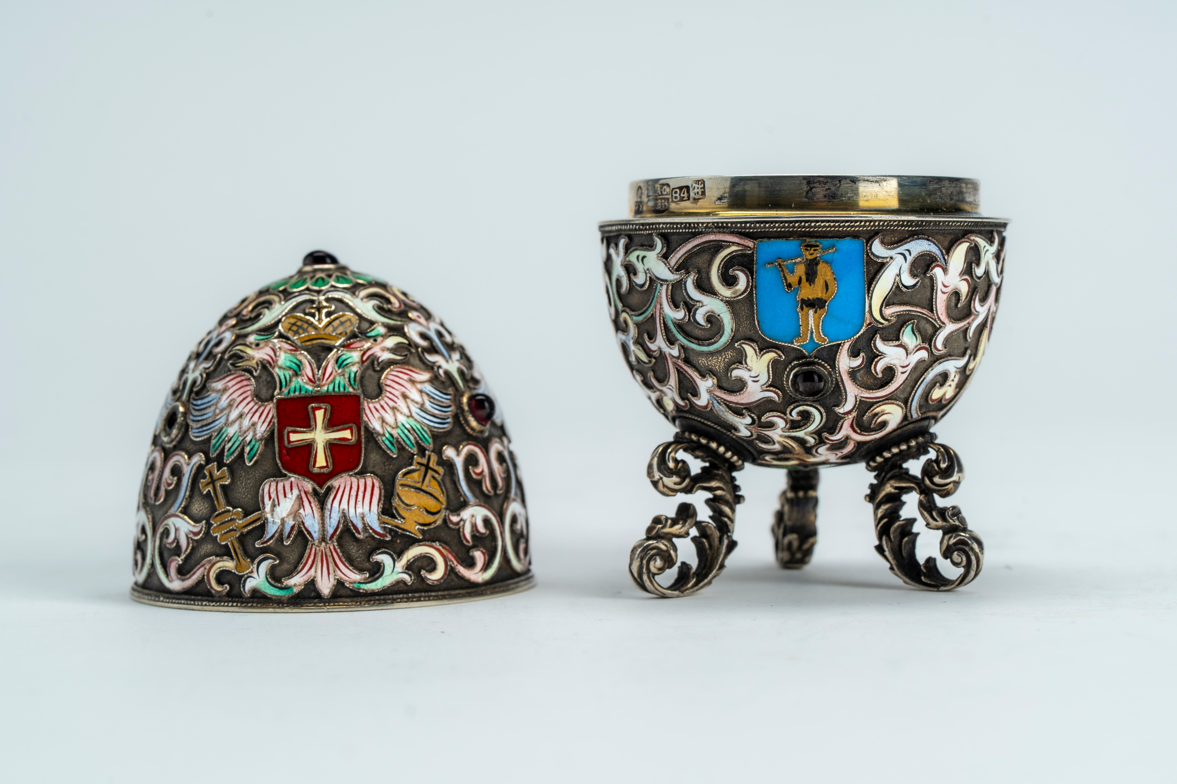 Uovo in argento con smalti policromi cloisonné e cabochons, poggiante su tre piedini a volute fog...