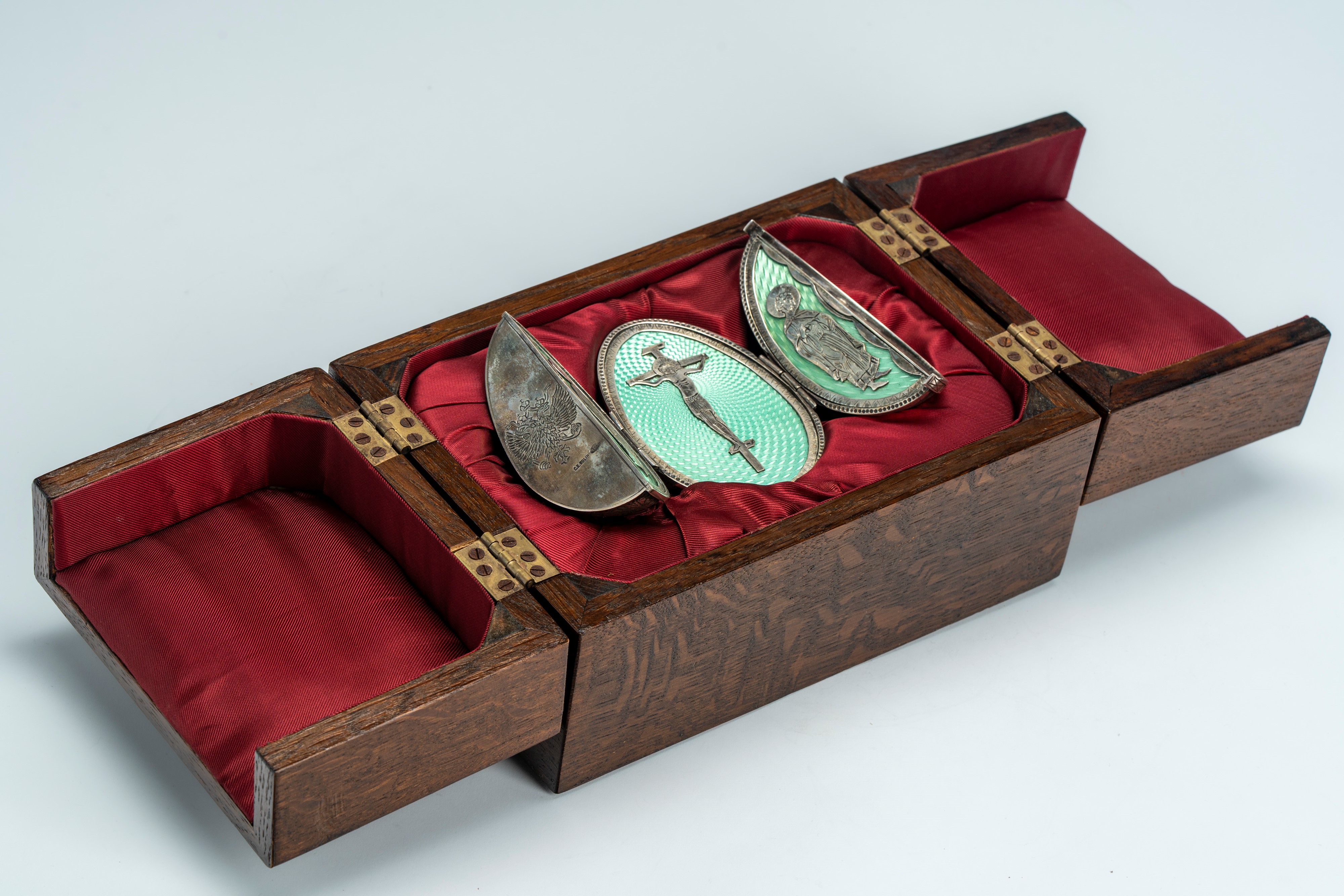 Uovo tripartito in argento e smalti guilloché, cesellato al niello con volute vegetali e aquila i...