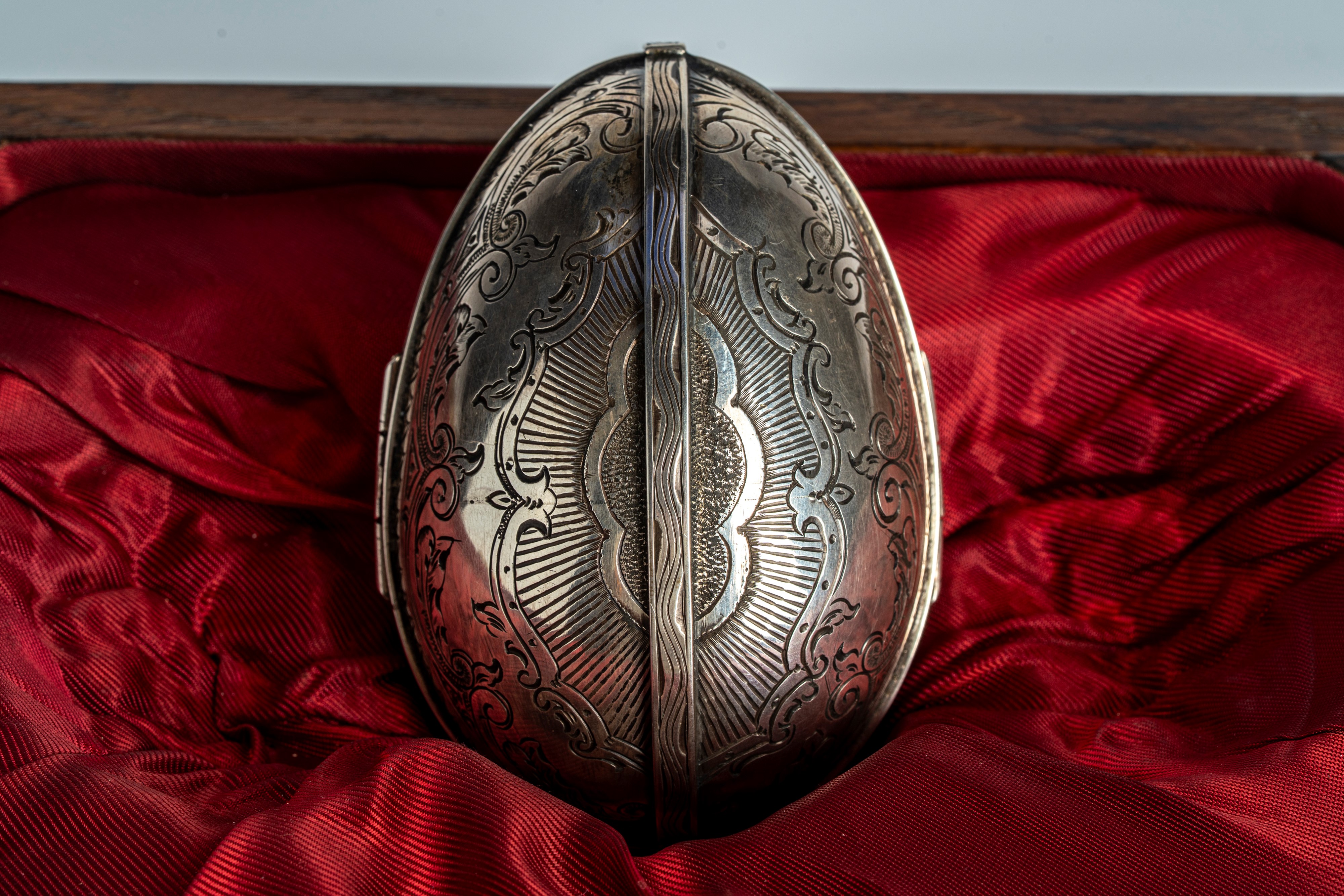 Uovo tripartito in argento e smalti guilloché, cesellato al niello con volute vegetali e aquila i...