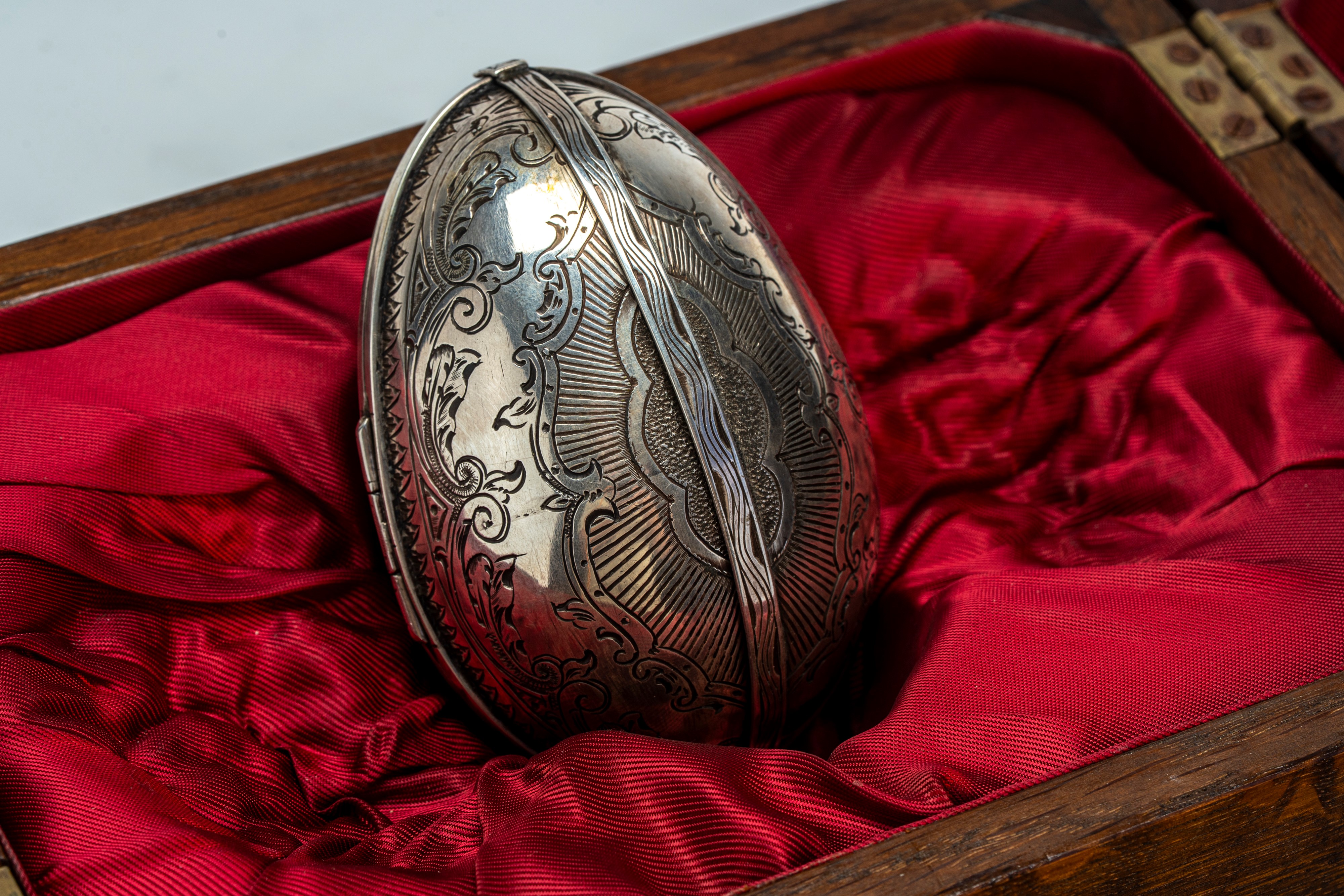 Uovo tripartito in argento e smalti guilloché, cesellato al niello con volute vegetali e aquila i...