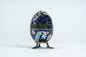 Uovo con coperchio incernierato in argento dorato con smalti policromi cloisonné a motivi floreali su fondo blu. Mosca, inizio secolo XX