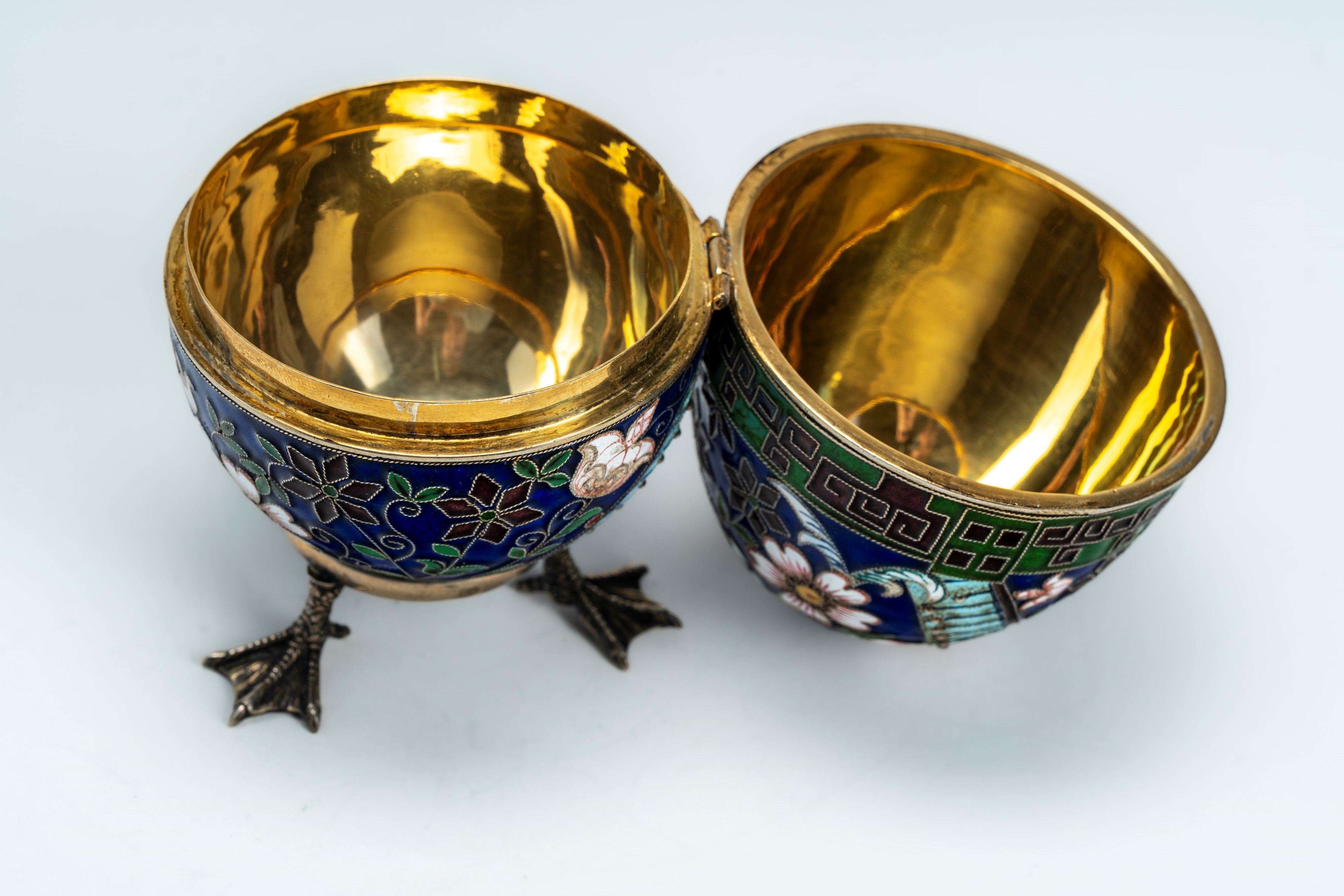 Uovo con coperchio incernierato in argento dorato con smalti policromi cloisonné a motivi floreal...