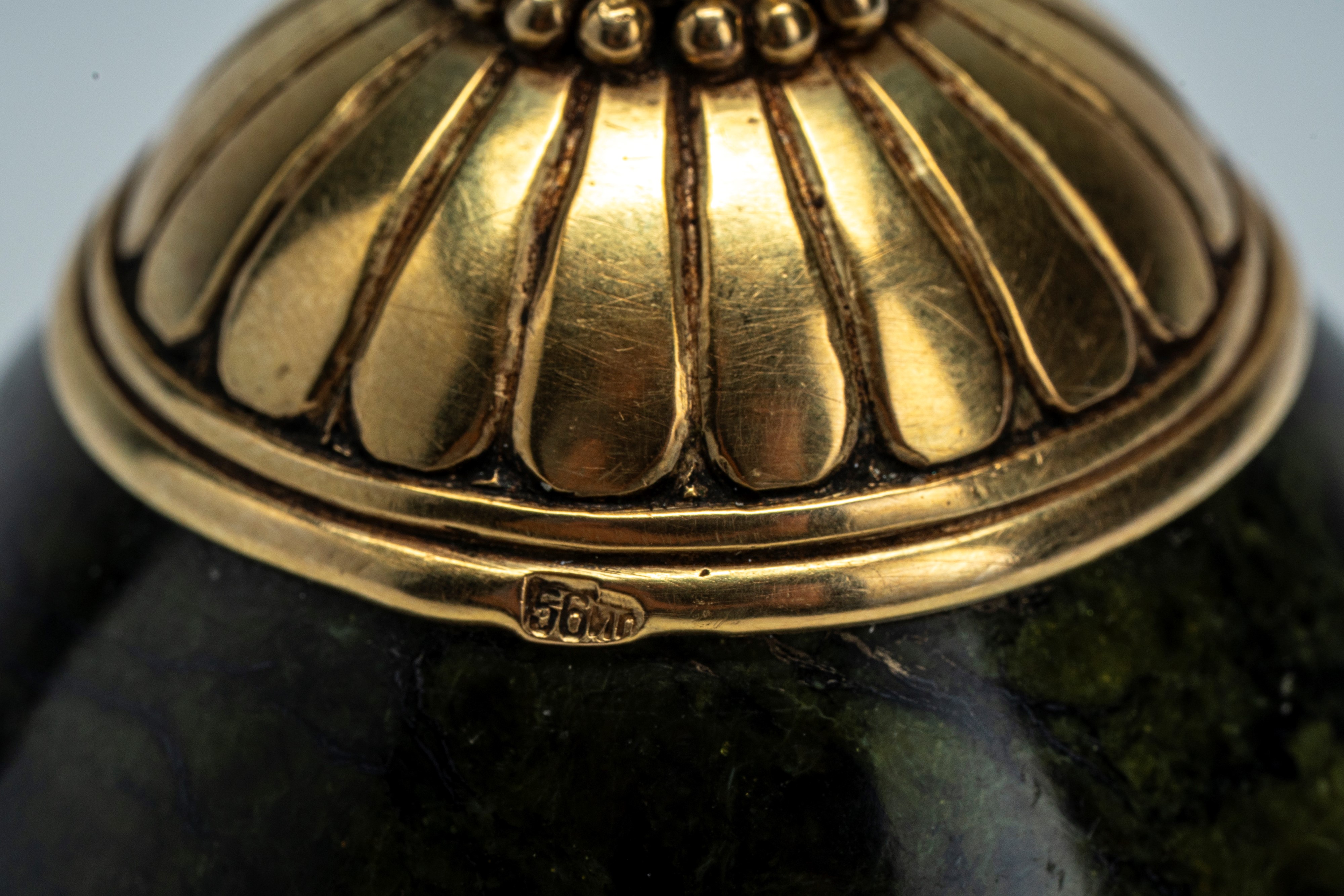 Uovo in nefrite montato in oro 56 zolotniki con base circolare incisa a palmette e finale a pomol...