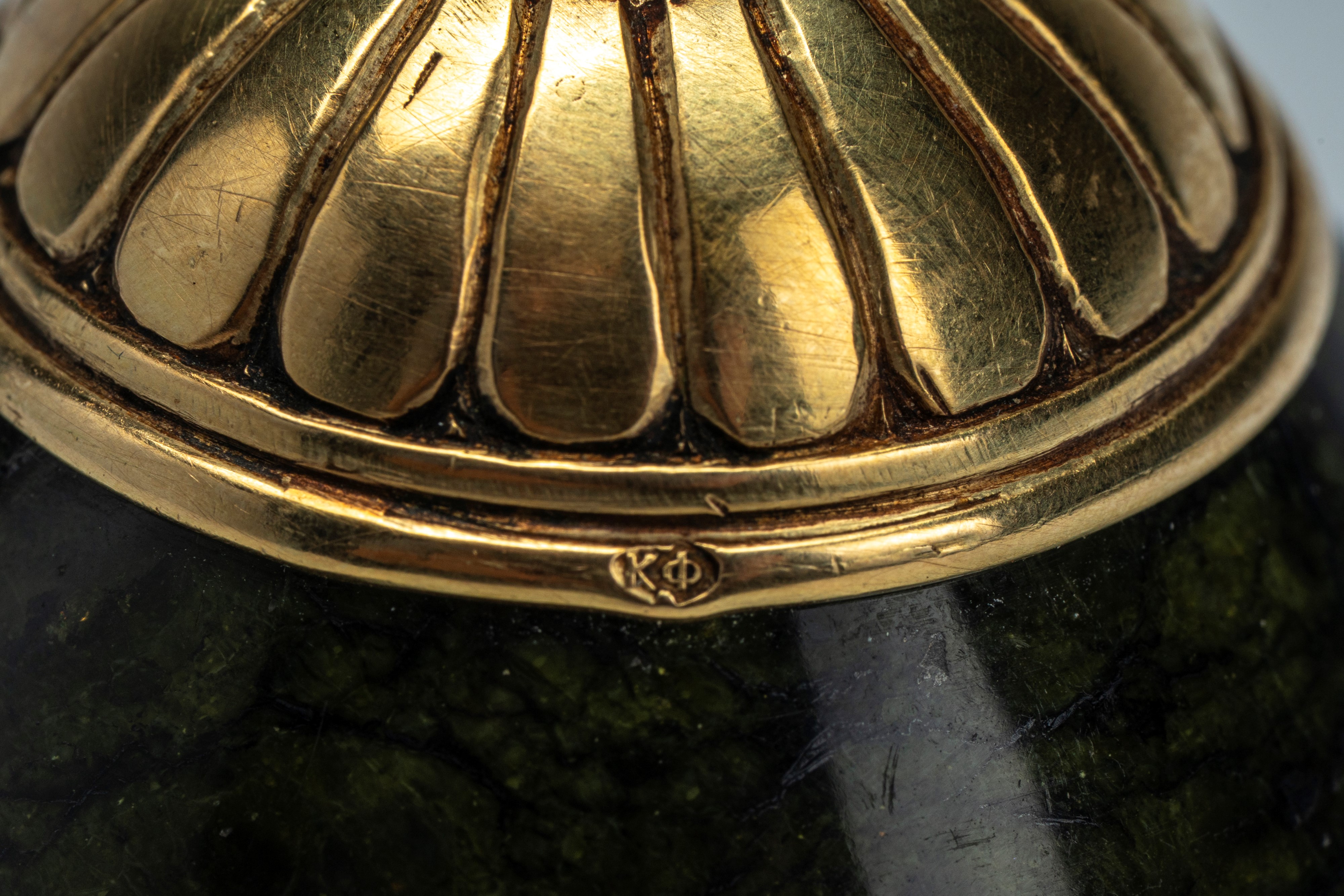 Uovo in nefrite montato in oro 56 zolotniki con base circolare incisa a palmette e finale a pomol...