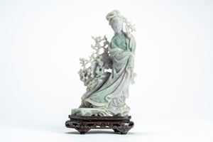 Jadeite figure of a lady in long robes leaning against a flowering trunk, China, 20th century