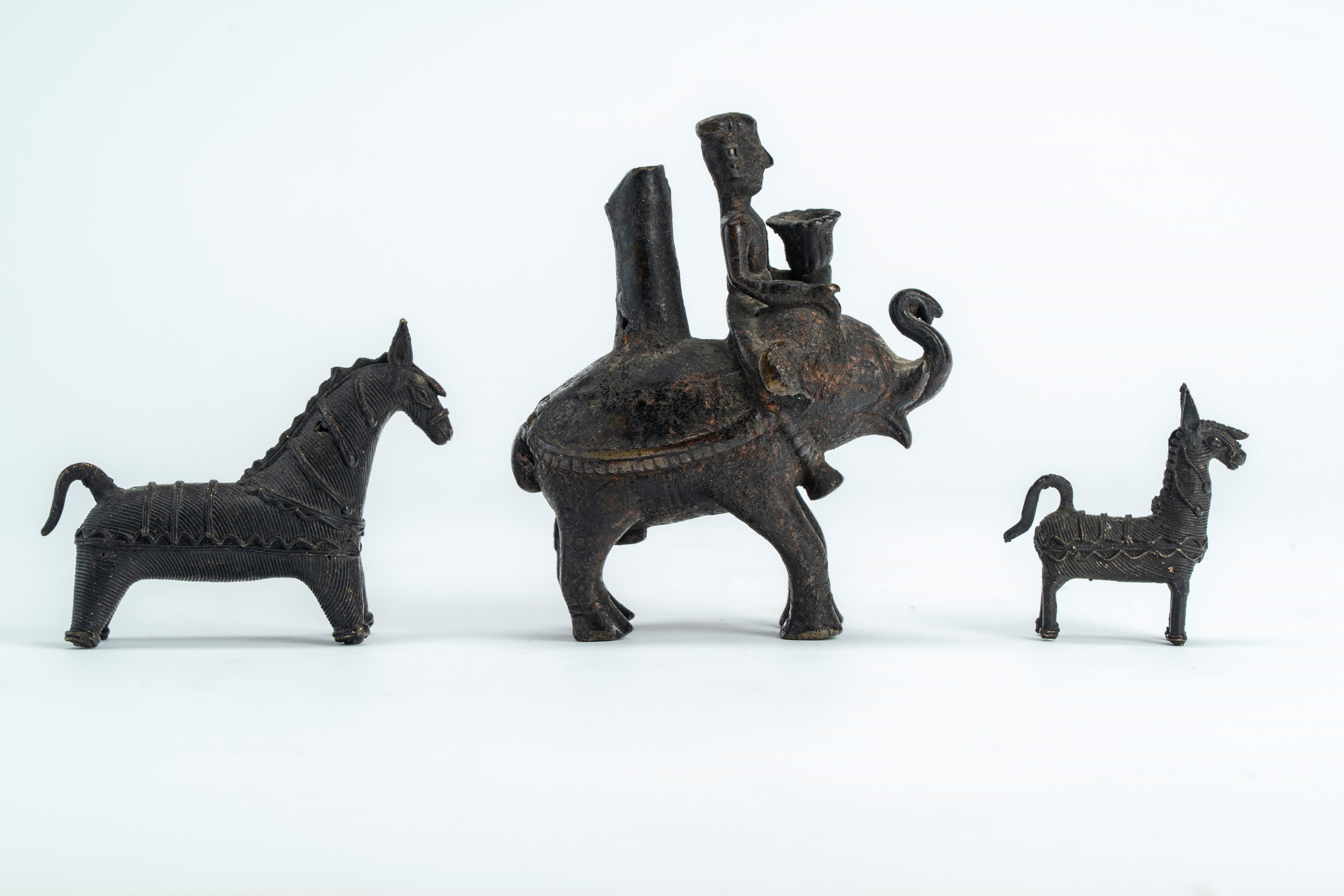 Sculture in ottone e bronzo, Lotto di tre opere raffiguranti cavalli votivi e un incensiere a for...