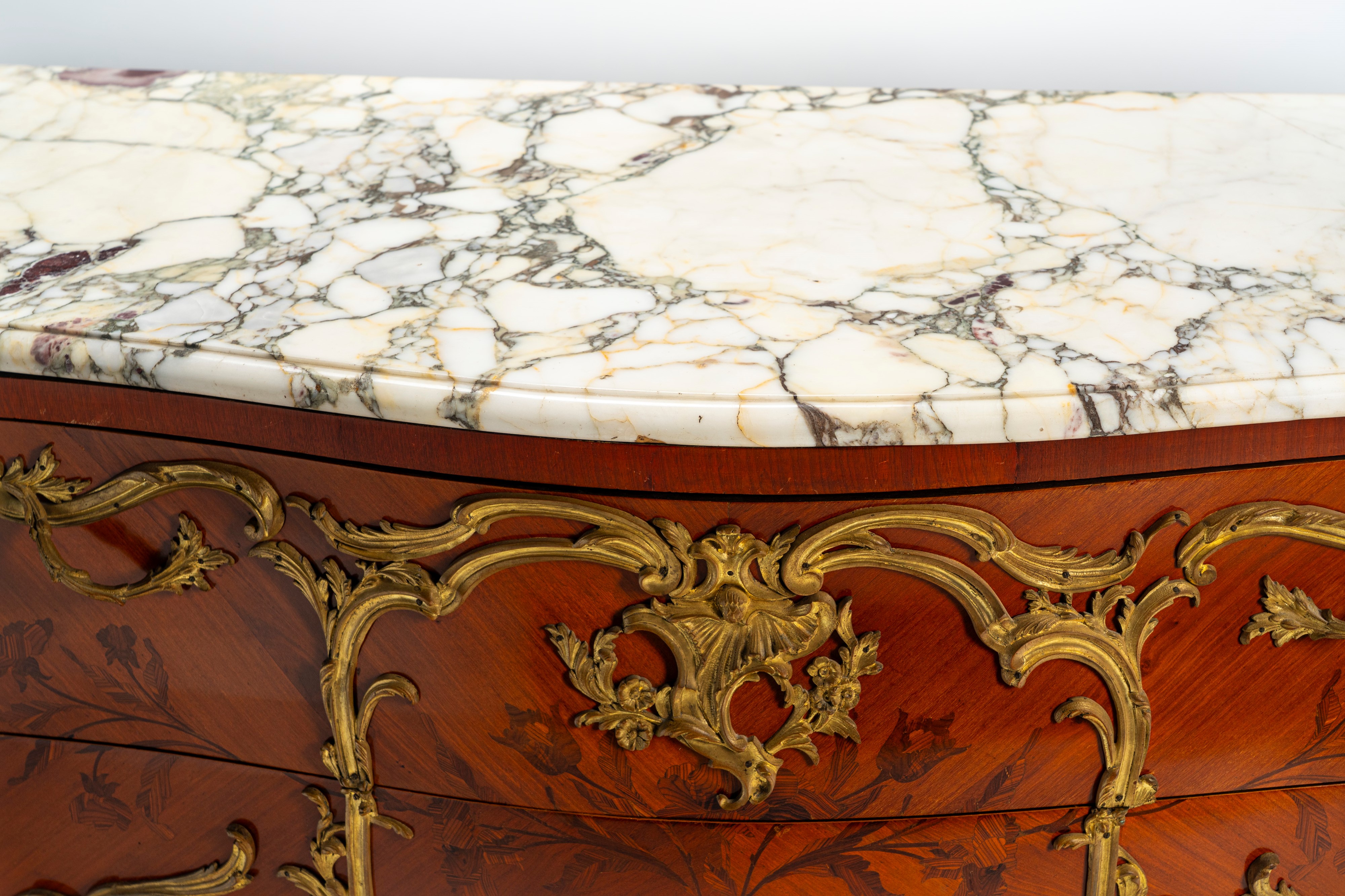Commode di gusto francese Luigi XV di forma mossa e bombata impiallacciata e intarsiata a motivi ...