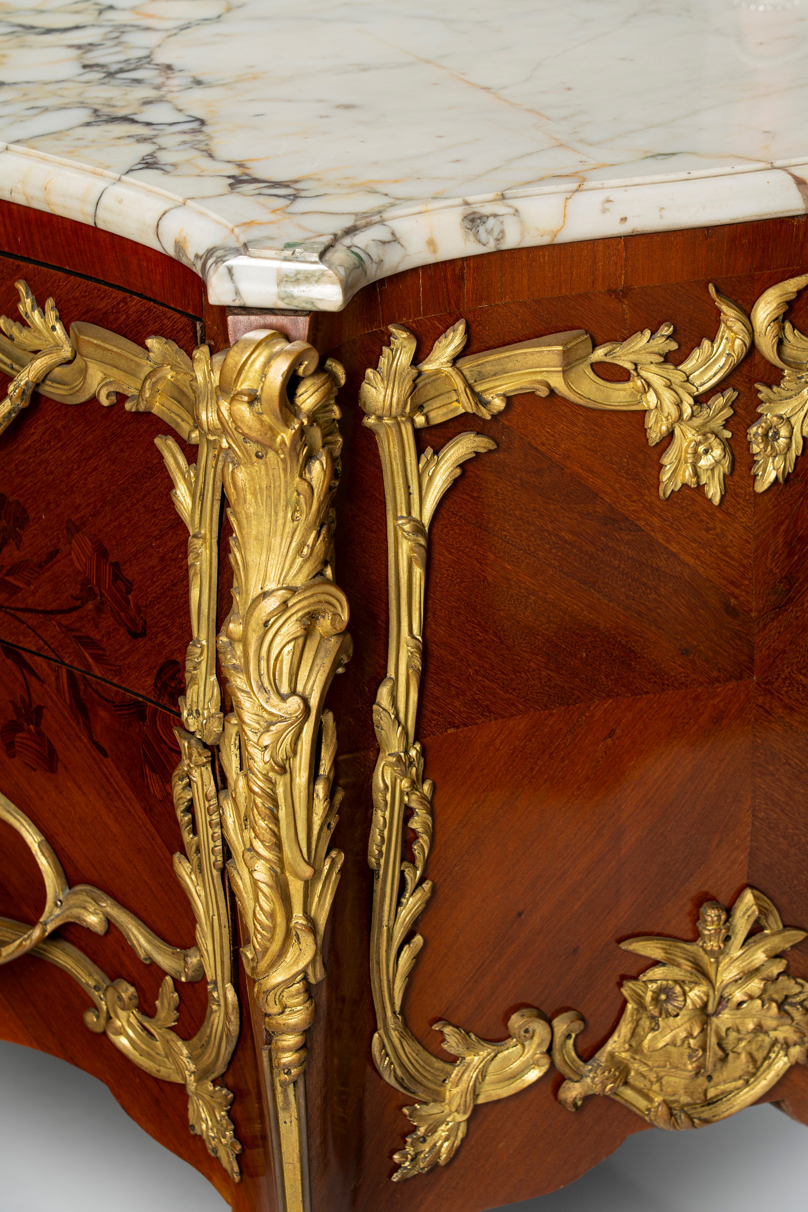 Commode di gusto francese Luigi XV di forma mossa e bombata impiallacciata e intarsiata a motivi ...