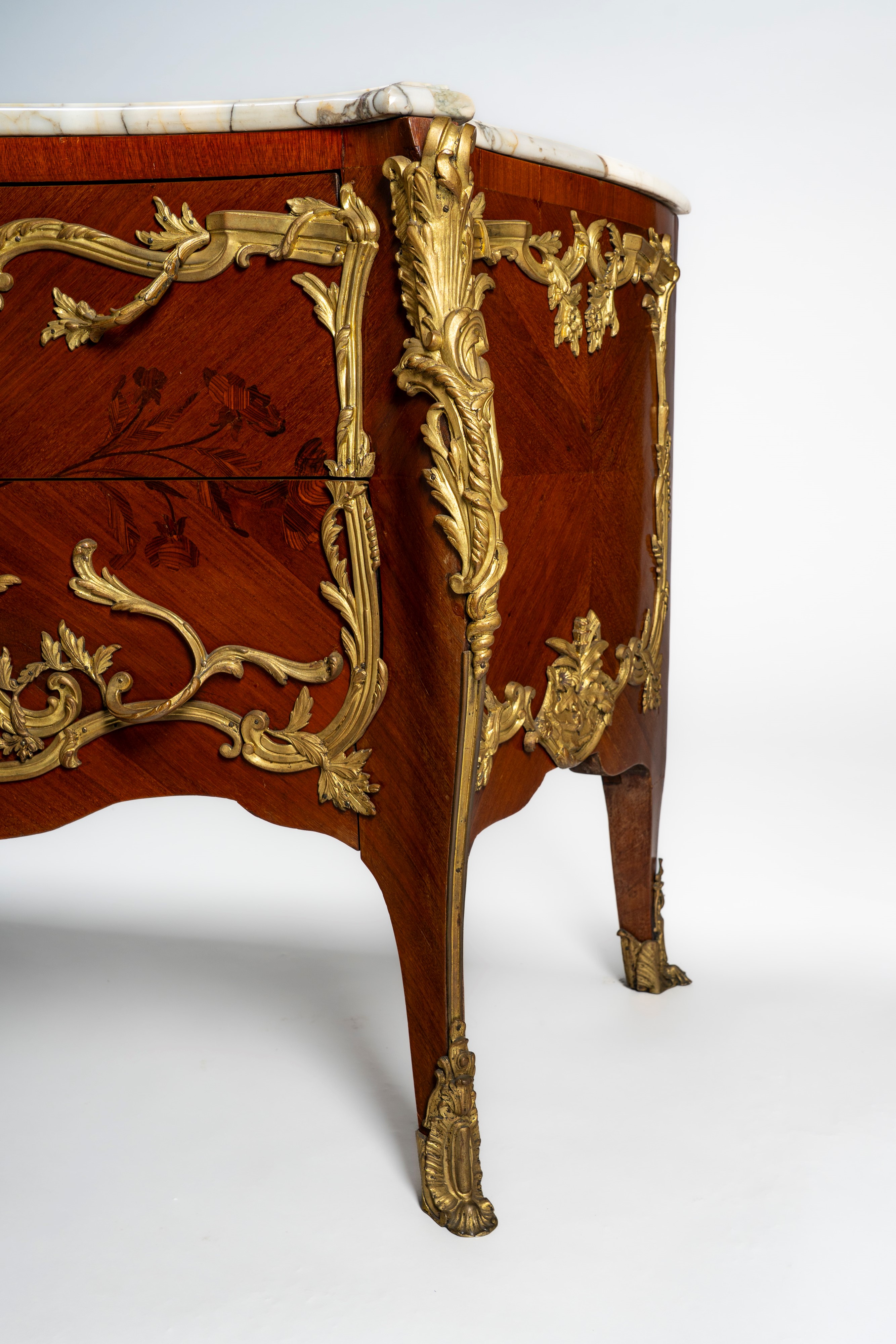 Commode di gusto francese Luigi XV di forma mossa e bombata impiallacciata e intarsiata a motivi ...