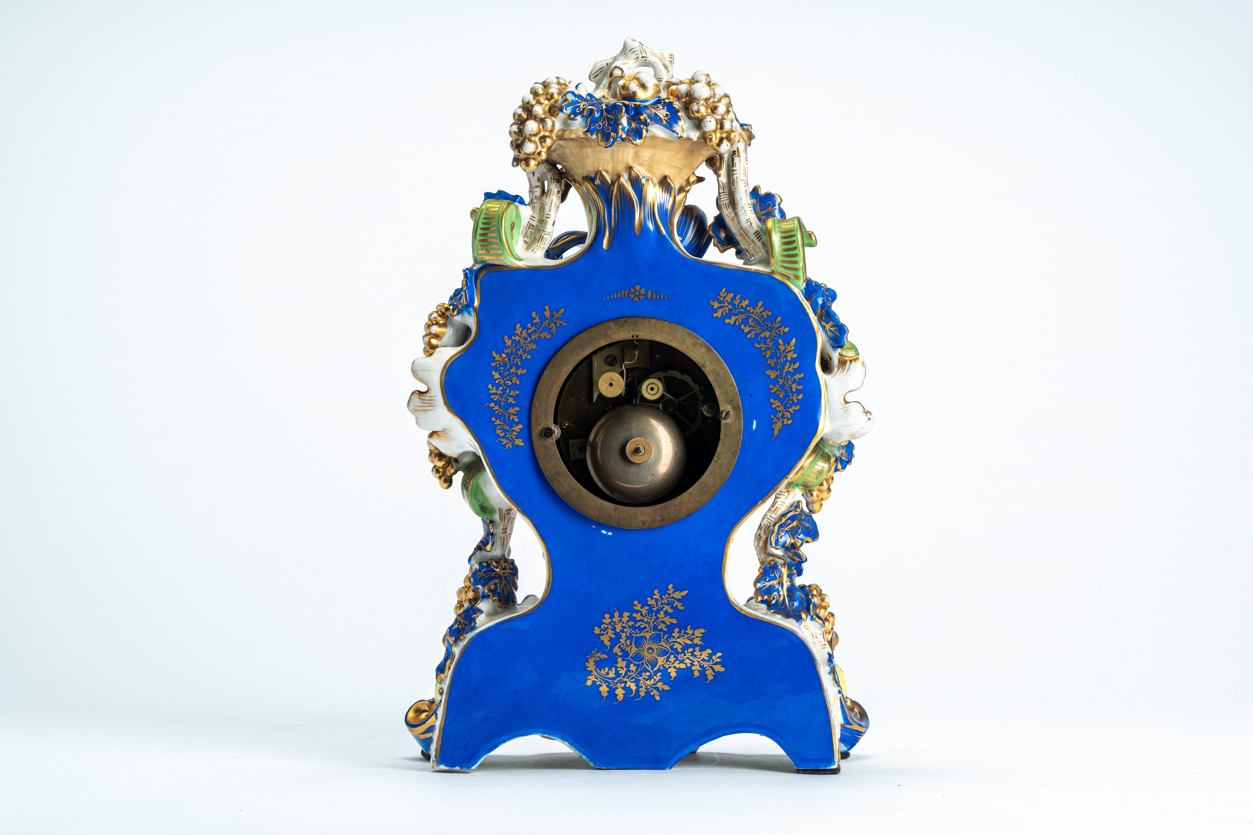 Pendola di forma mossa in porcellana policroma e dorata riccamente decorata a tralci di vite, pog...