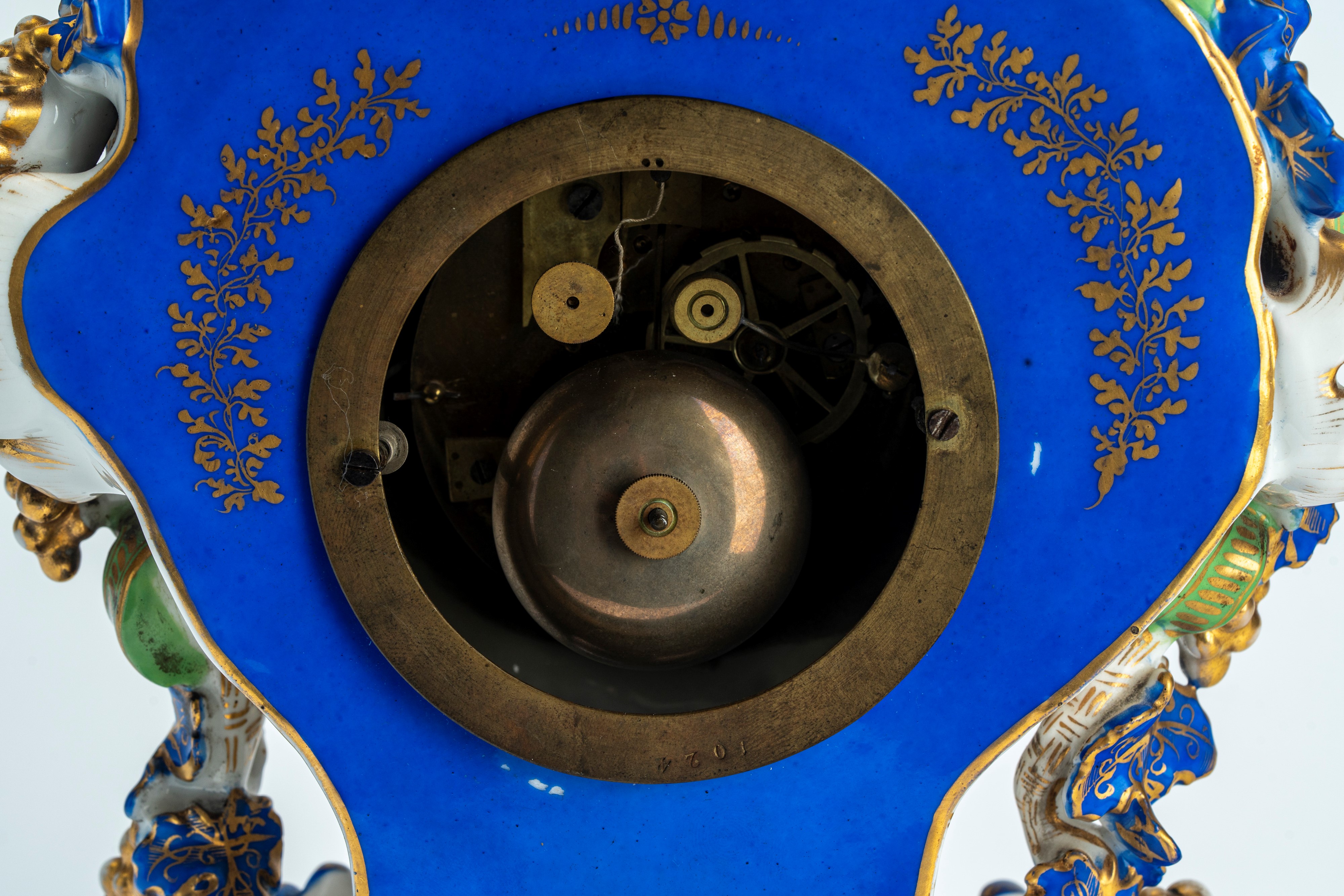 Pendola di forma mossa in porcellana policroma e dorata riccamente decorata a tralci di vite, pog...