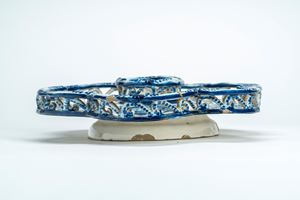 Alzata esalobata con ringhiera traforata in maiolica decorata in monocromia blu cobalto a volute fogliate e stemma. Manifattura di Savona o Albissola, secolo XVIII