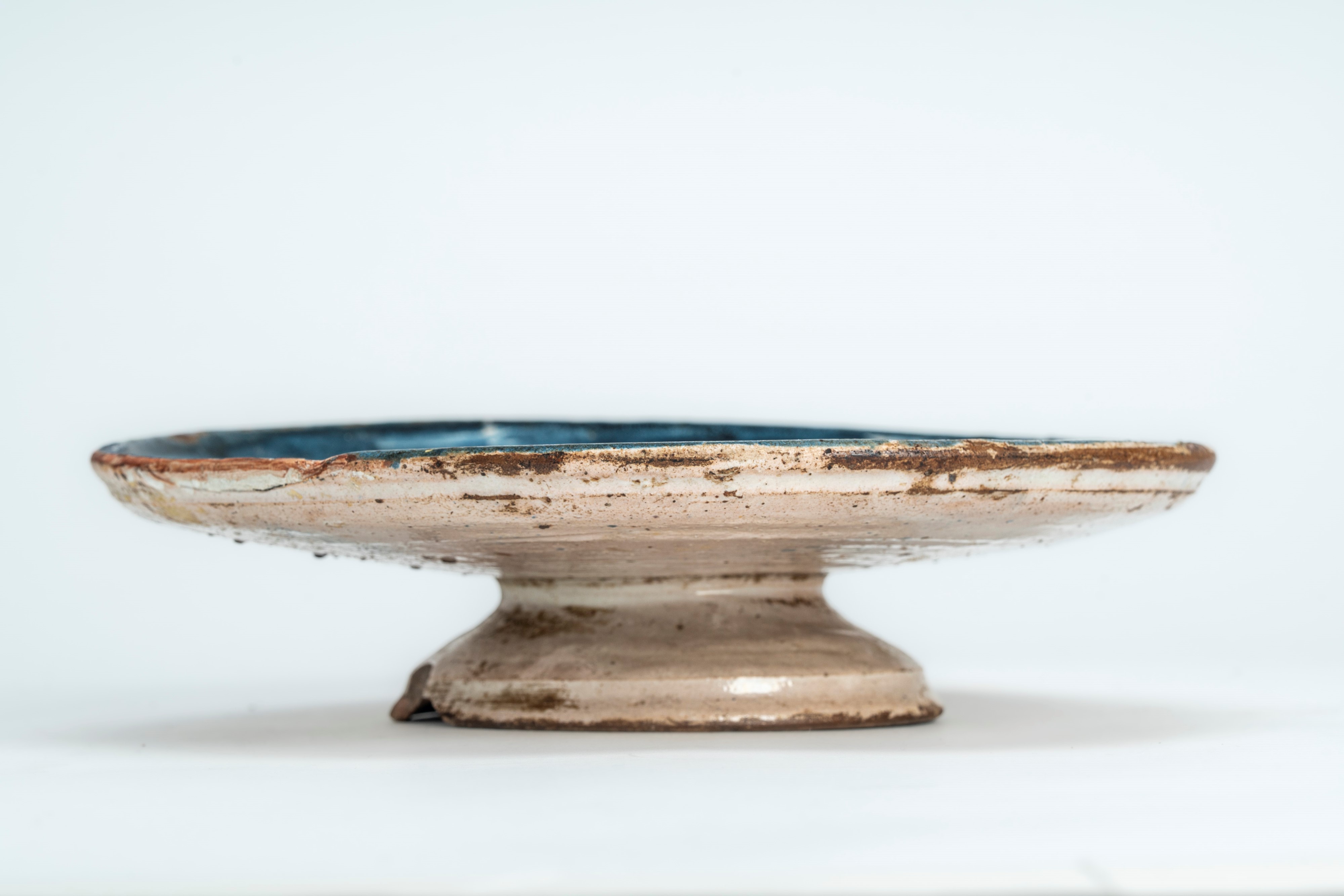 Alzata in terracotta smaltata con decoro blu cobalto a volatile in un paesaggio stilizzato. Ligur...