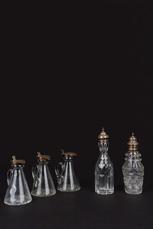 Lotto di tre bottigliette e due contenitori in cristallo con coperchio in argento 