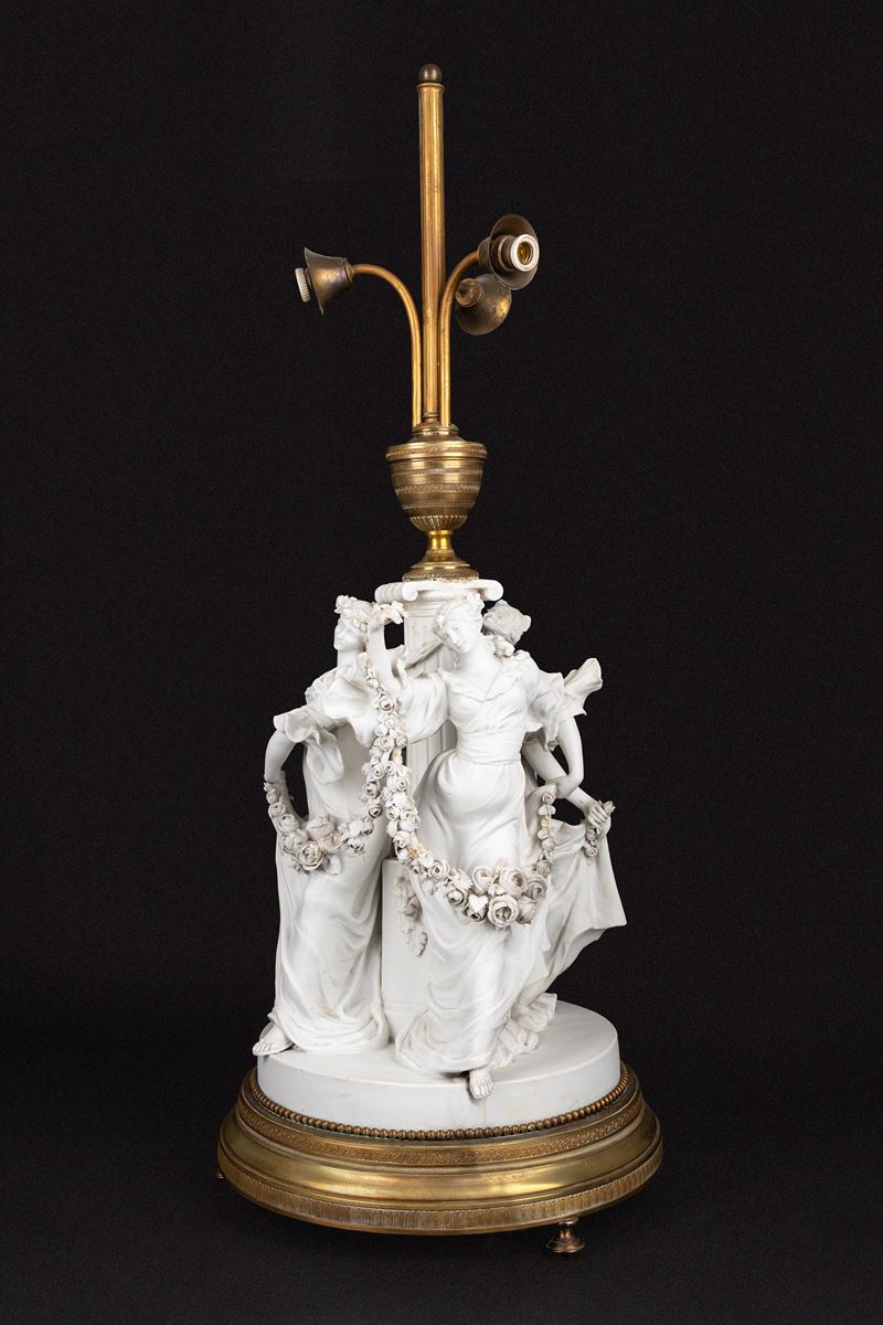 Lampada da tavolo in biscuit e bronzo dorato, con fusto con tre fanciulle danzanti e ghirlande di...