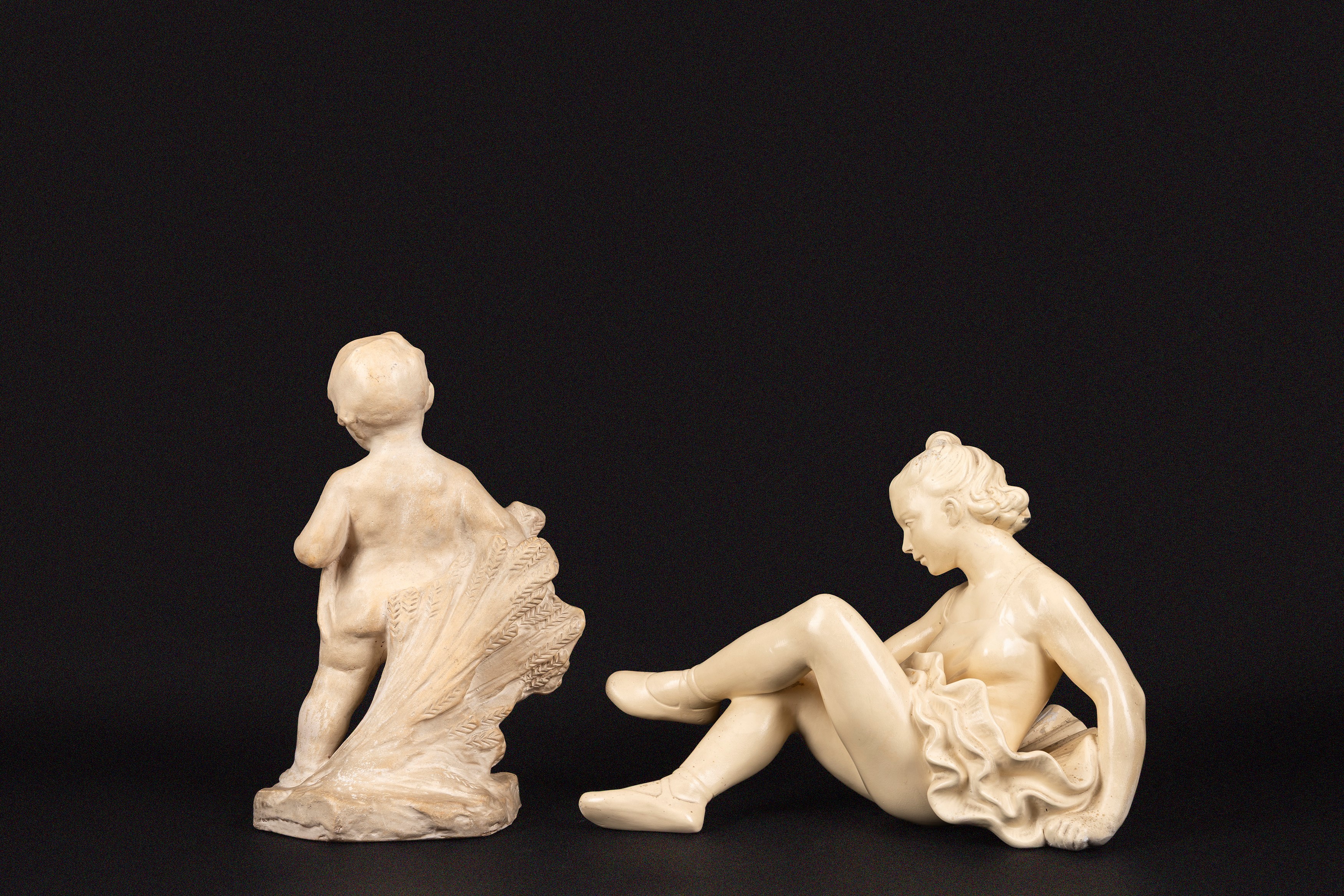 Due sculture, ceramica bianca, raffigurazioni di ballerina e bambino con spighe