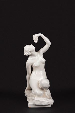 Scultura in porcellana bianca raffigurante nudo di donna con grappolo d'uva