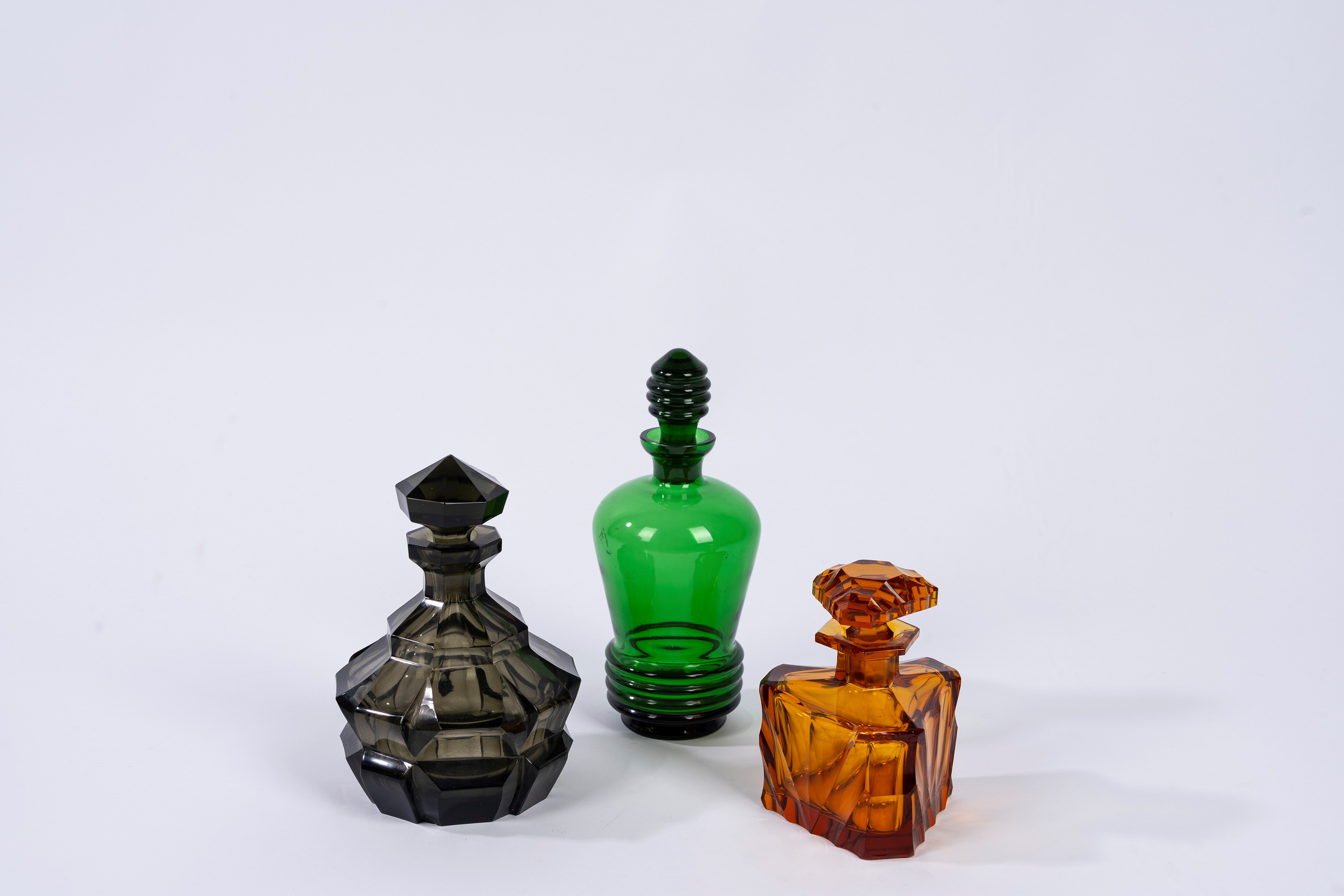 Set di tre bottiglie in vetro art déco, varie colorazioni