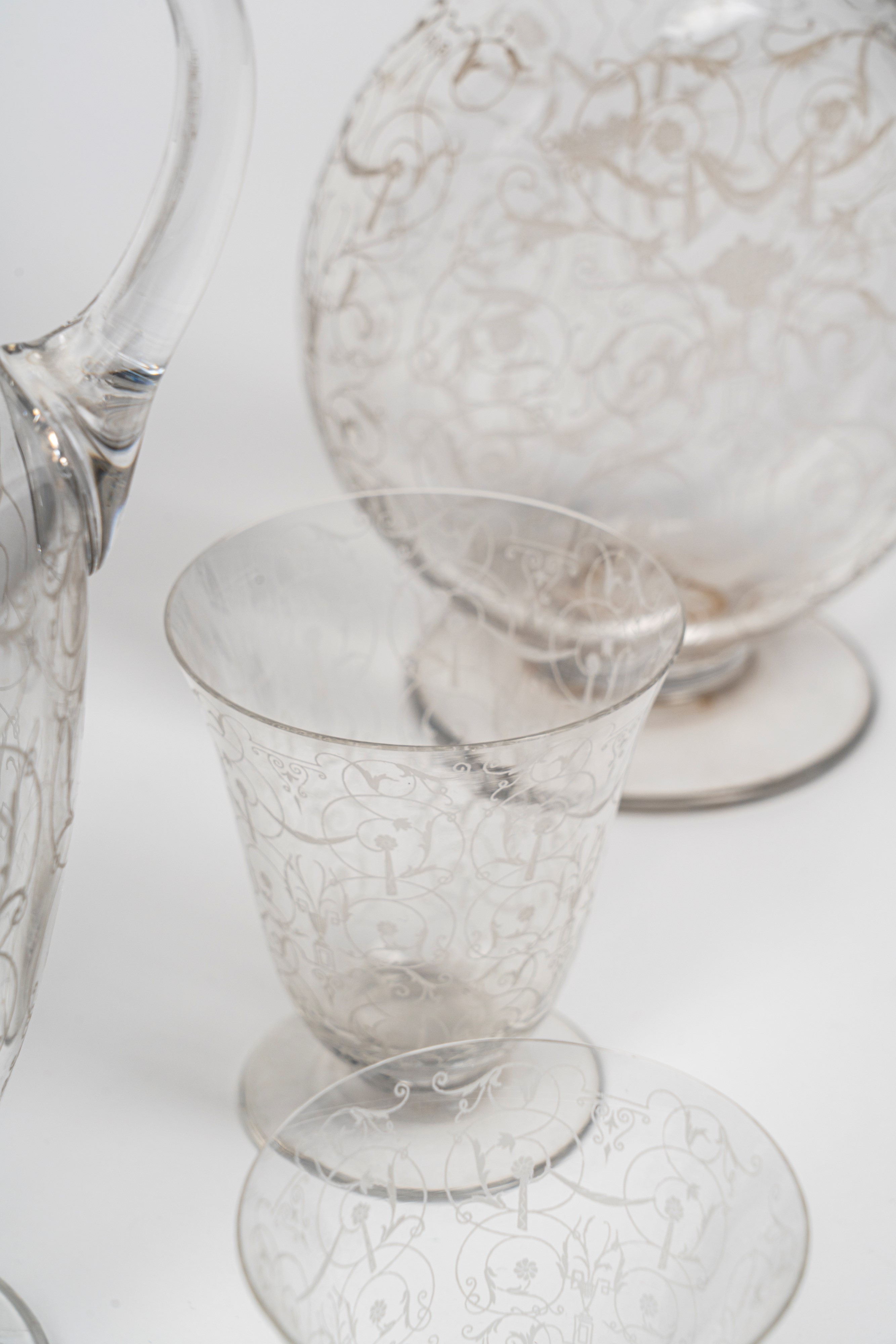Servizio in cristallo, composto da caraffe, bottiglie e calici decorati a motivi a girali con fog...