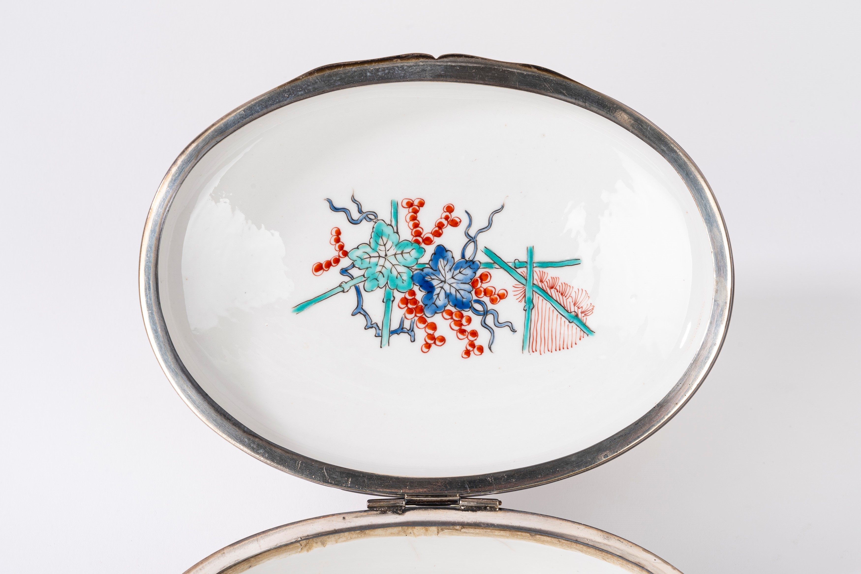 Scatola in porcellana bianca decorata in policromia a chinoiserie, con bordo in argento