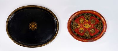 Due vassoi in metallo laccato, uno nero e oro con motivo floreale e uno rosso, oro e nero
