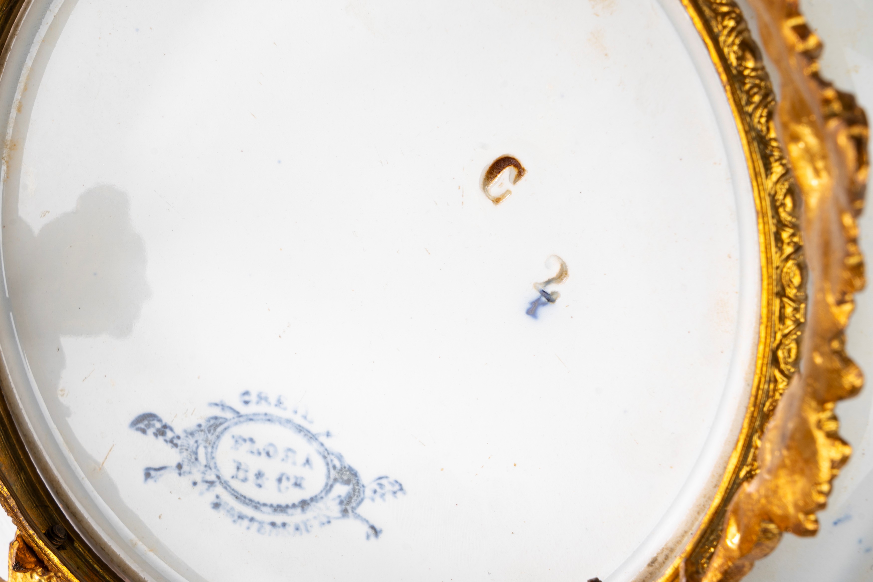 Tre piatti e un’alzatina in porcellana policroma con montatura in bronzo dorato, Francia