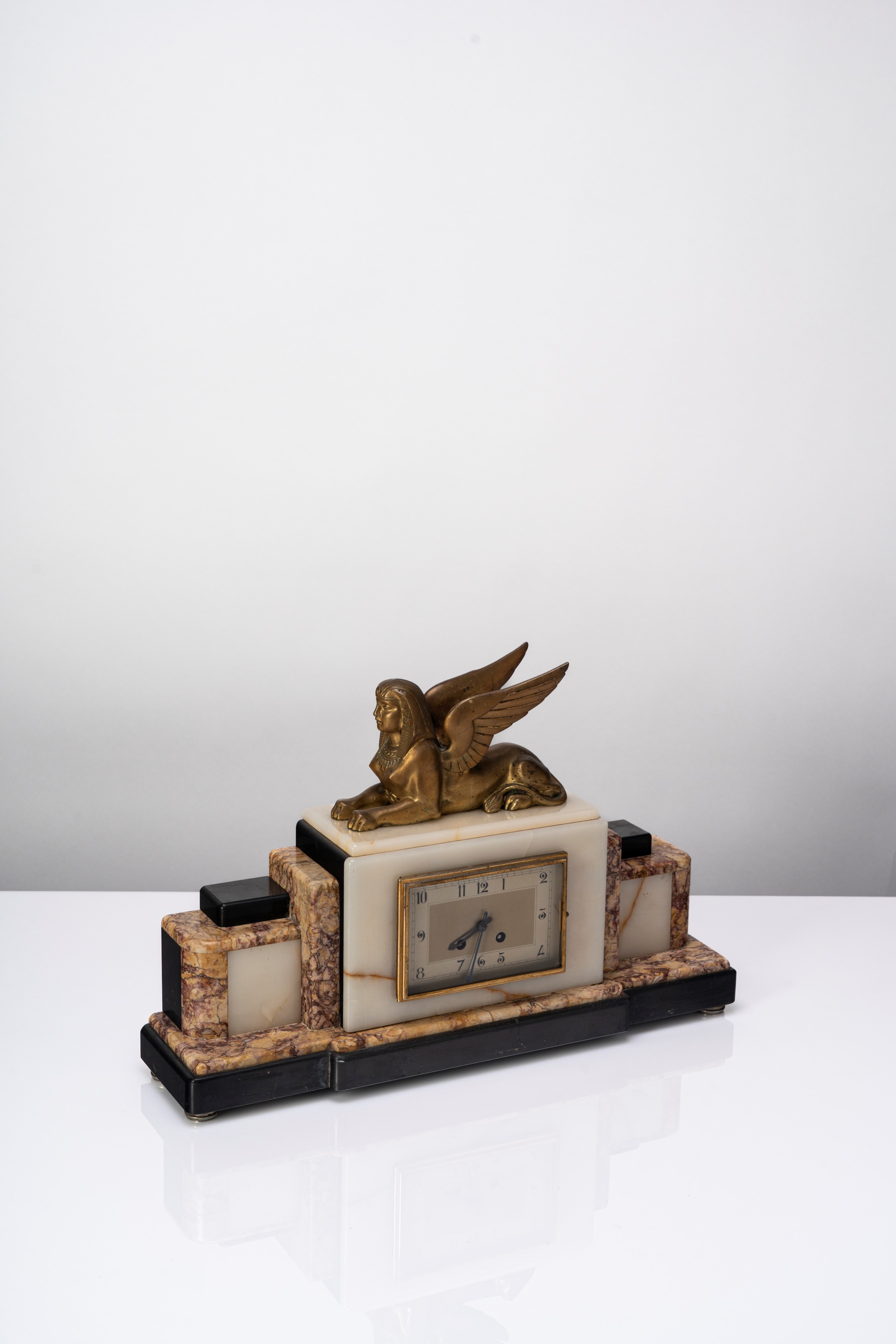 Manifattura Francese - Orologio da tavolo Art Déco in marmi policromi con sfinge alata in bronzo