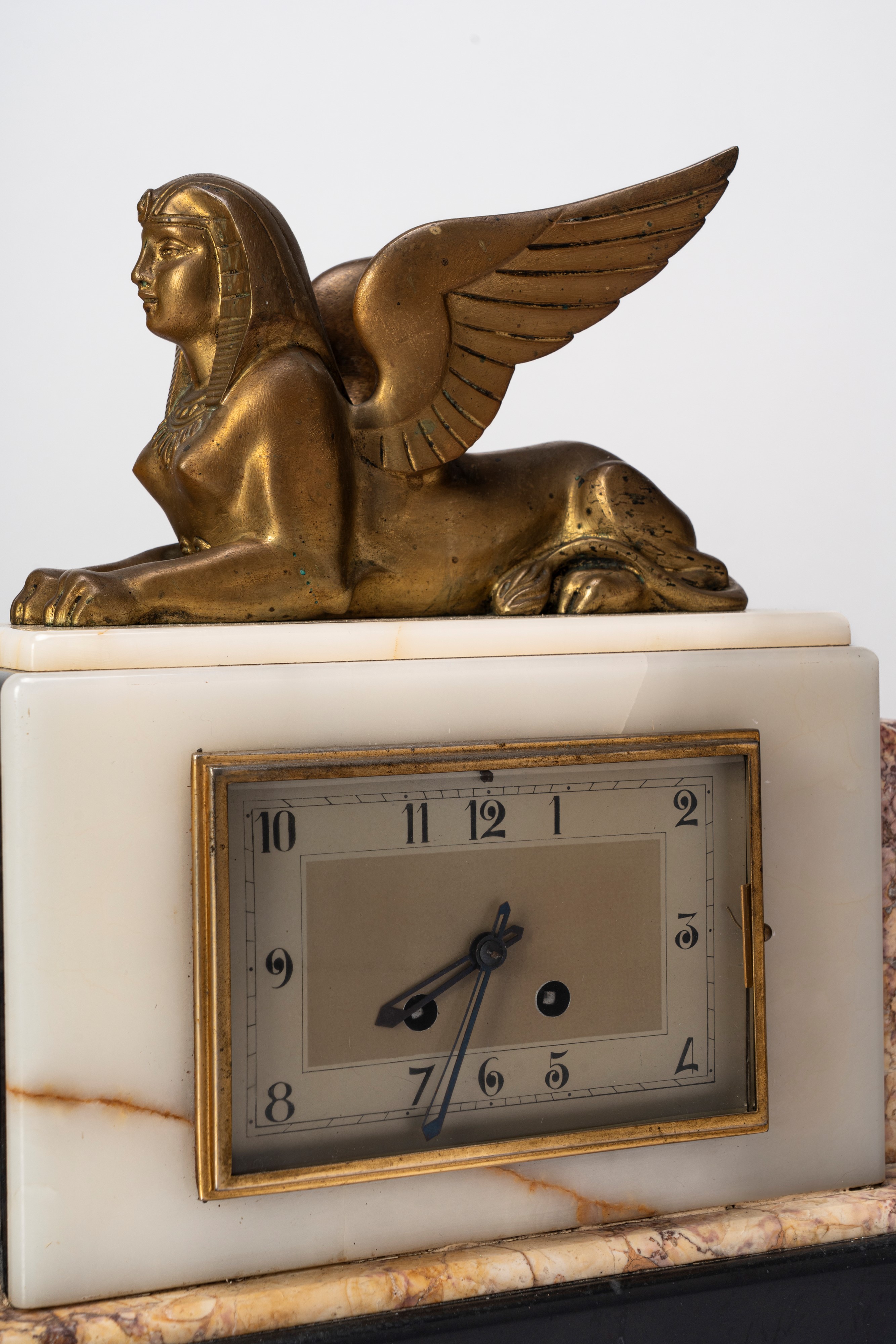 Manifattura Francese - Orologio da tavolo Art Déco in marmi policromi con sfinge alata in bronzo