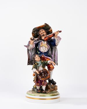 Gruppo scultoreo in porcellana policroma Capodimonte, raffigurante suonatore e piccolo mendicante, secolo XX