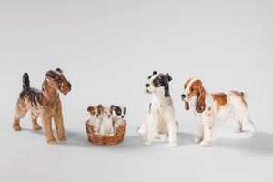 Due fox terrier, tre cuccioli di terrier e un cocker spaniel in porcellana policroma. Royal Doulton, Inghilterra, secolo XX
