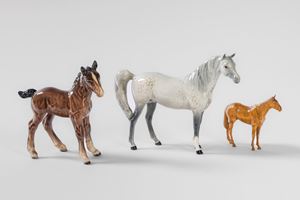 Un cavallo bianco e un cavallino in porcellana policroma. Beswick, Inghilterra, secolo XX. Pi&ugrave; un cavallo in legno scolpito e dipinto