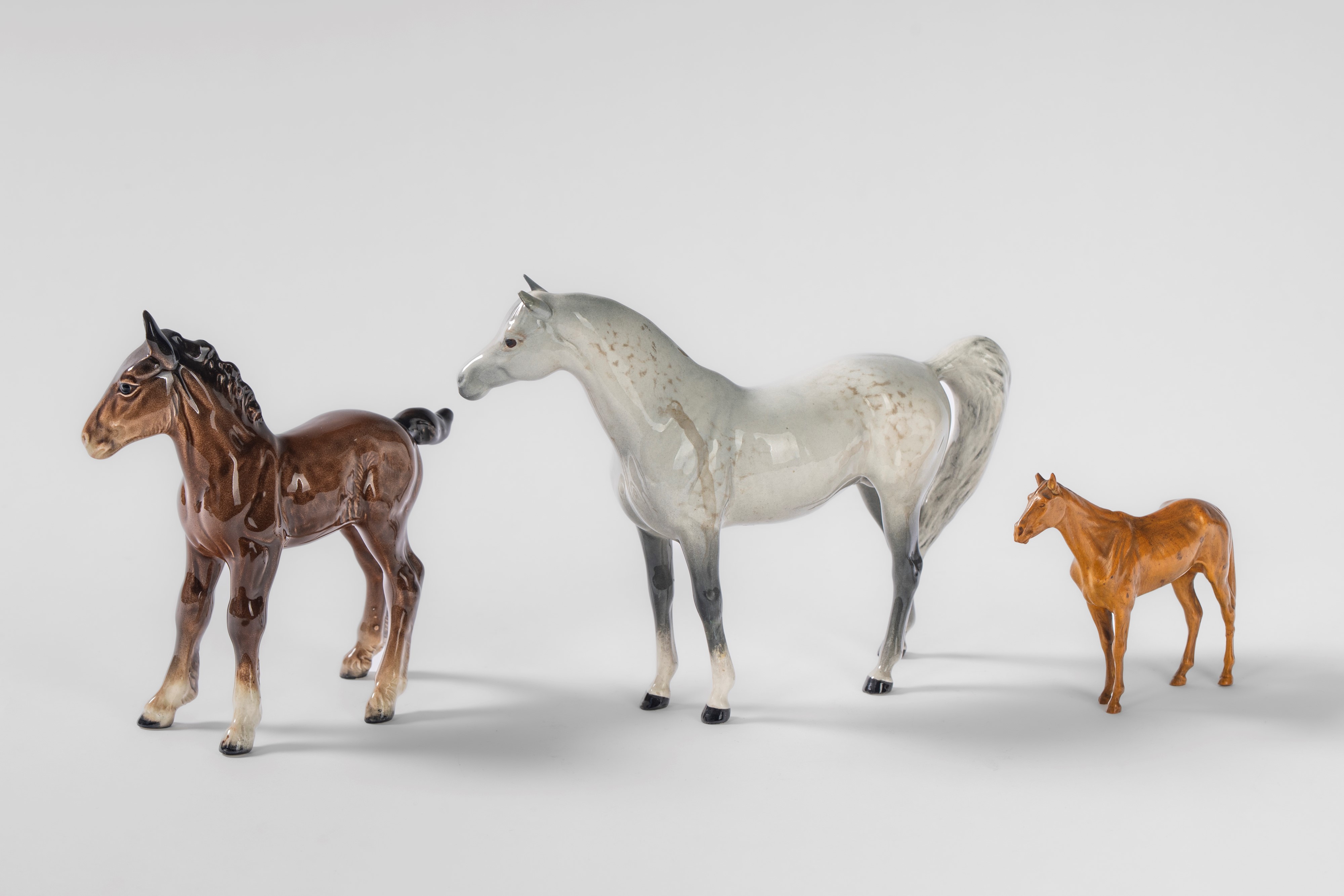 Beswick, Cavallo bianco e un cavallino in porcellana policroma, Inghilterra, XX secolo; insieme a...