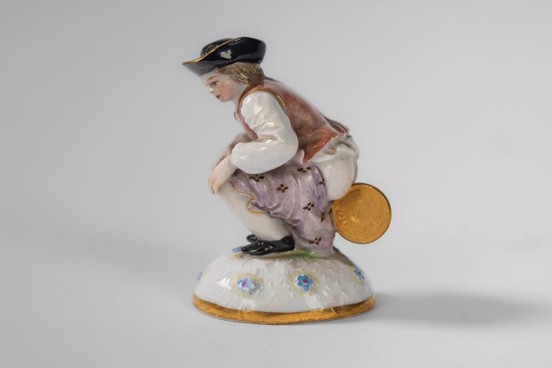 Figura satirica raffigurante "Dukatenscheißer" in porcellana policroma. Meissen, inizio secolo XX