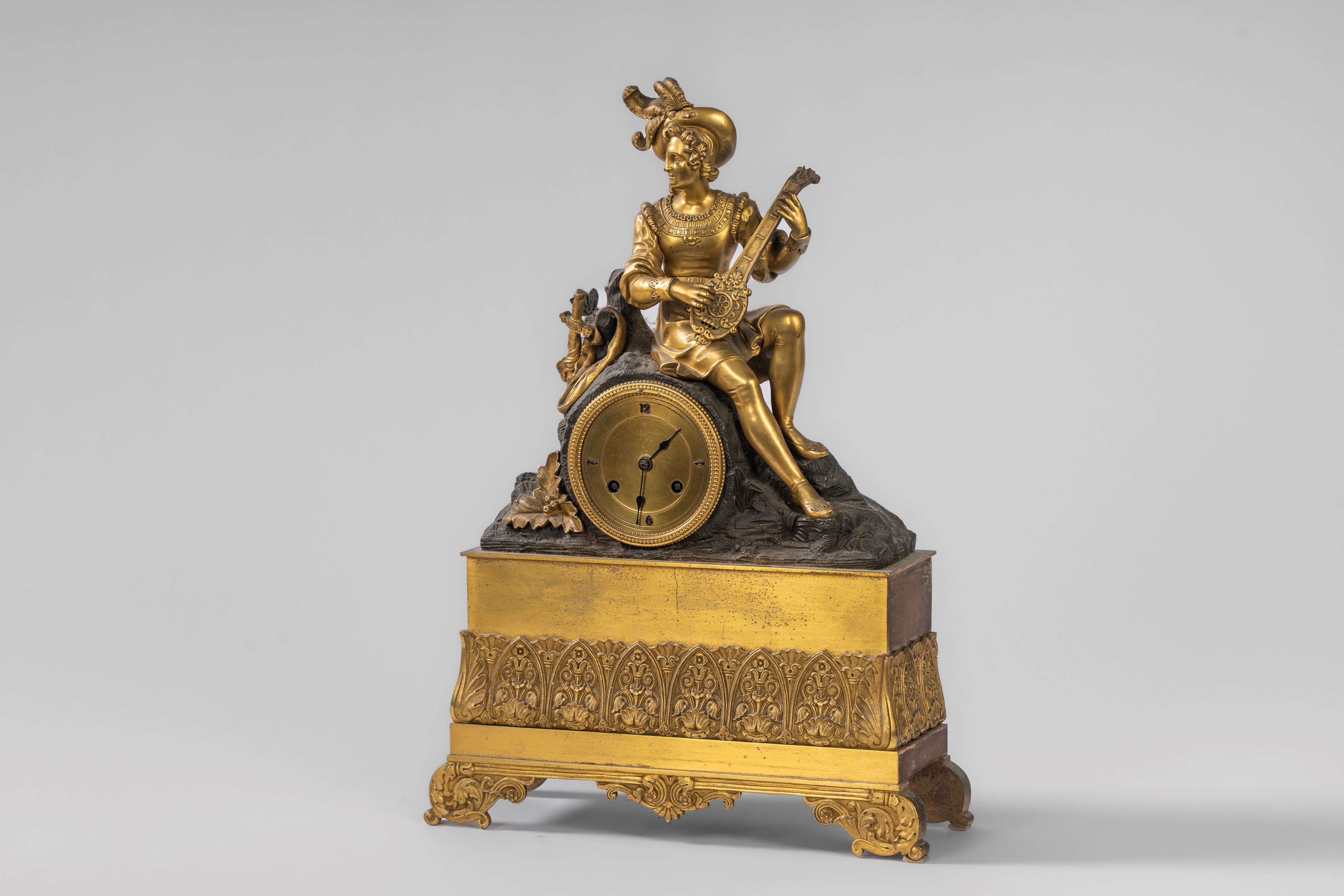 Pendola da appoggio in bronzo dorato e patinato con suonatore di liuto, Francia, primo quarto XIX...