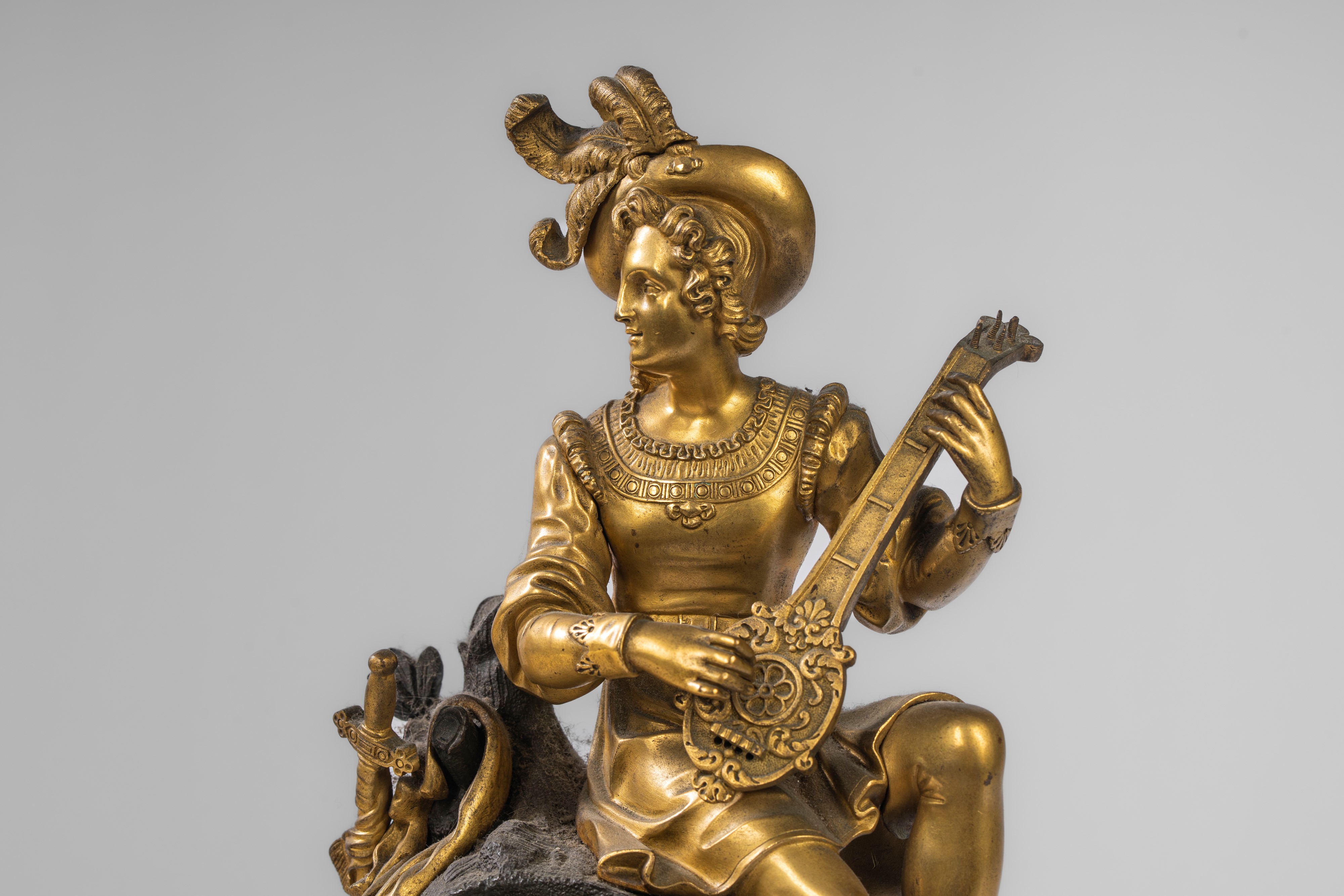Pendola da appoggio in bronzo dorato e patinato con suonatore di liuto, Francia, primo quarto XIX...