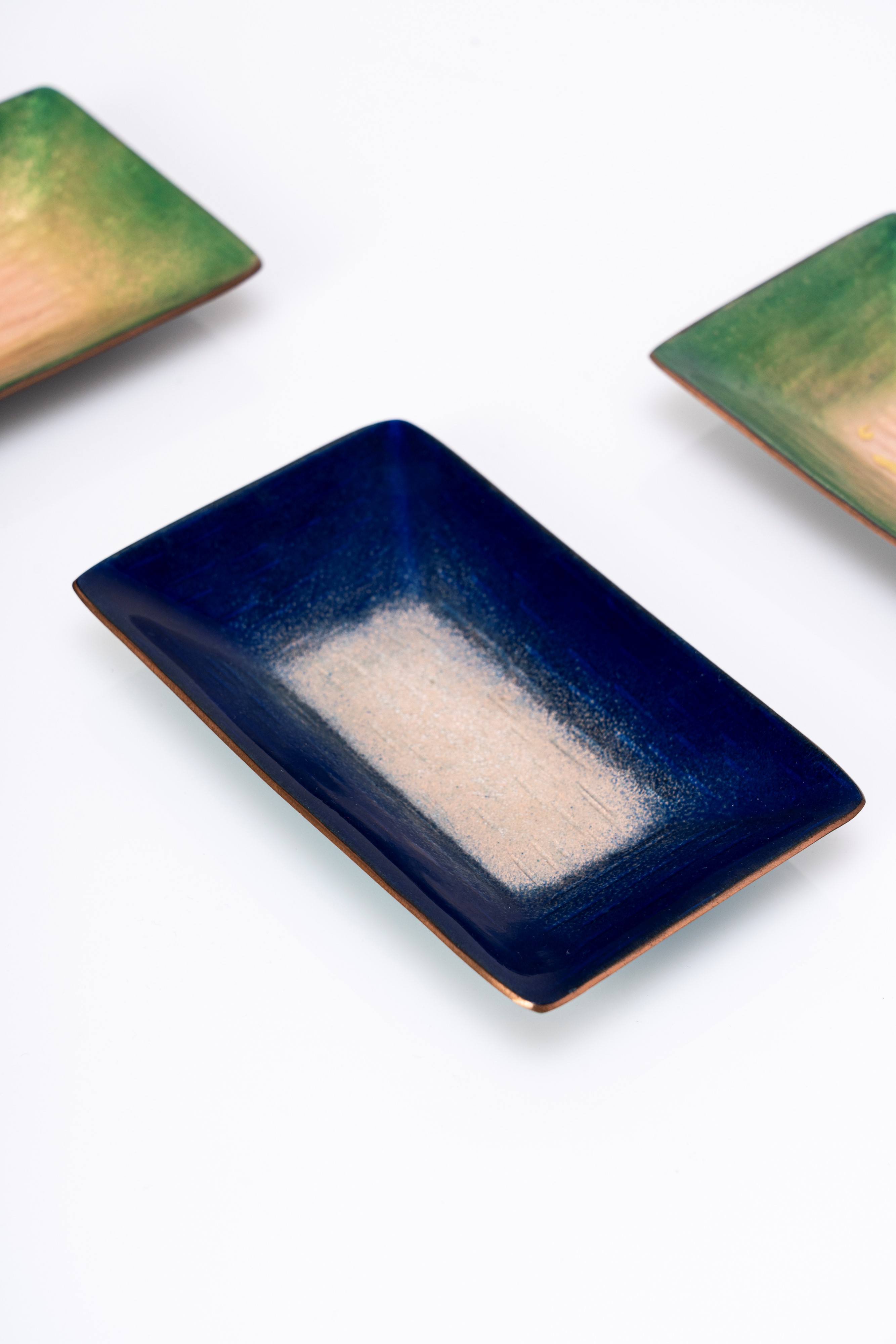 Set di tre svuotatasche a smalti policromi su rame nei toni del blu e verde